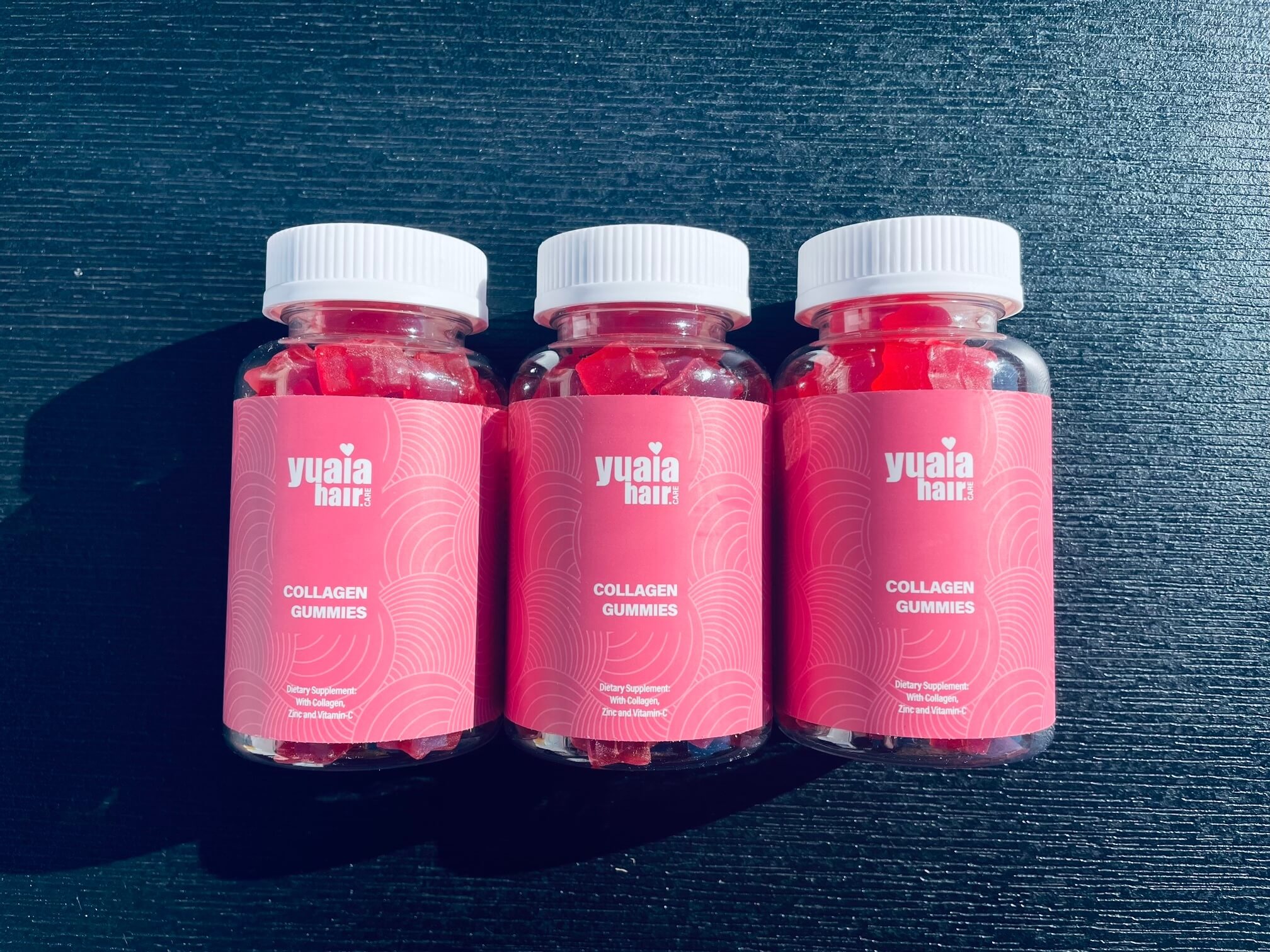 3 bøtter collagen gummies på et bord