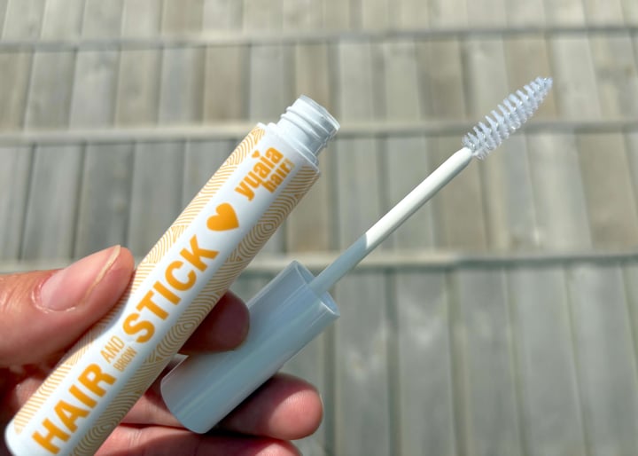 Åben Yuaia Haircare Hair and Brow Stick i hånd