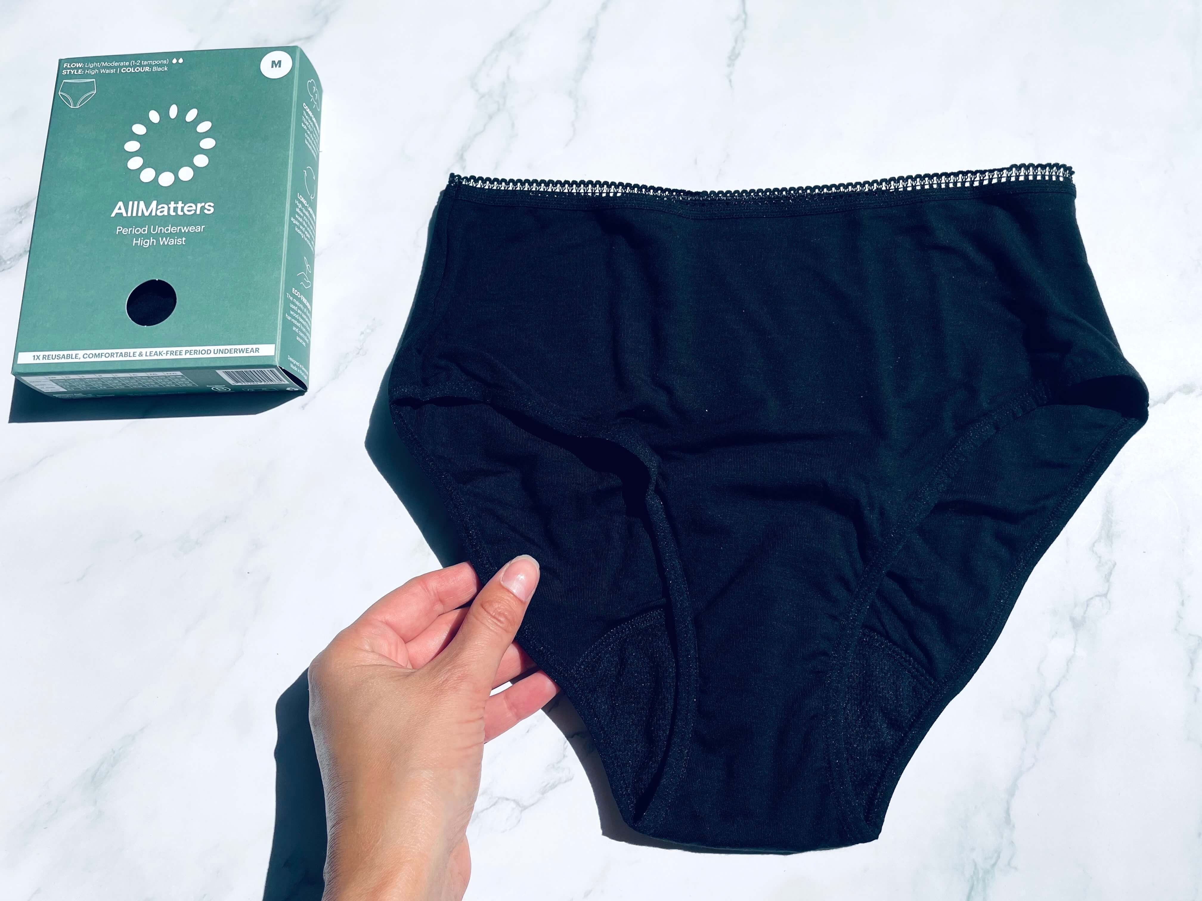AllMatters menstruationstrusse med kasse og i en hånd 