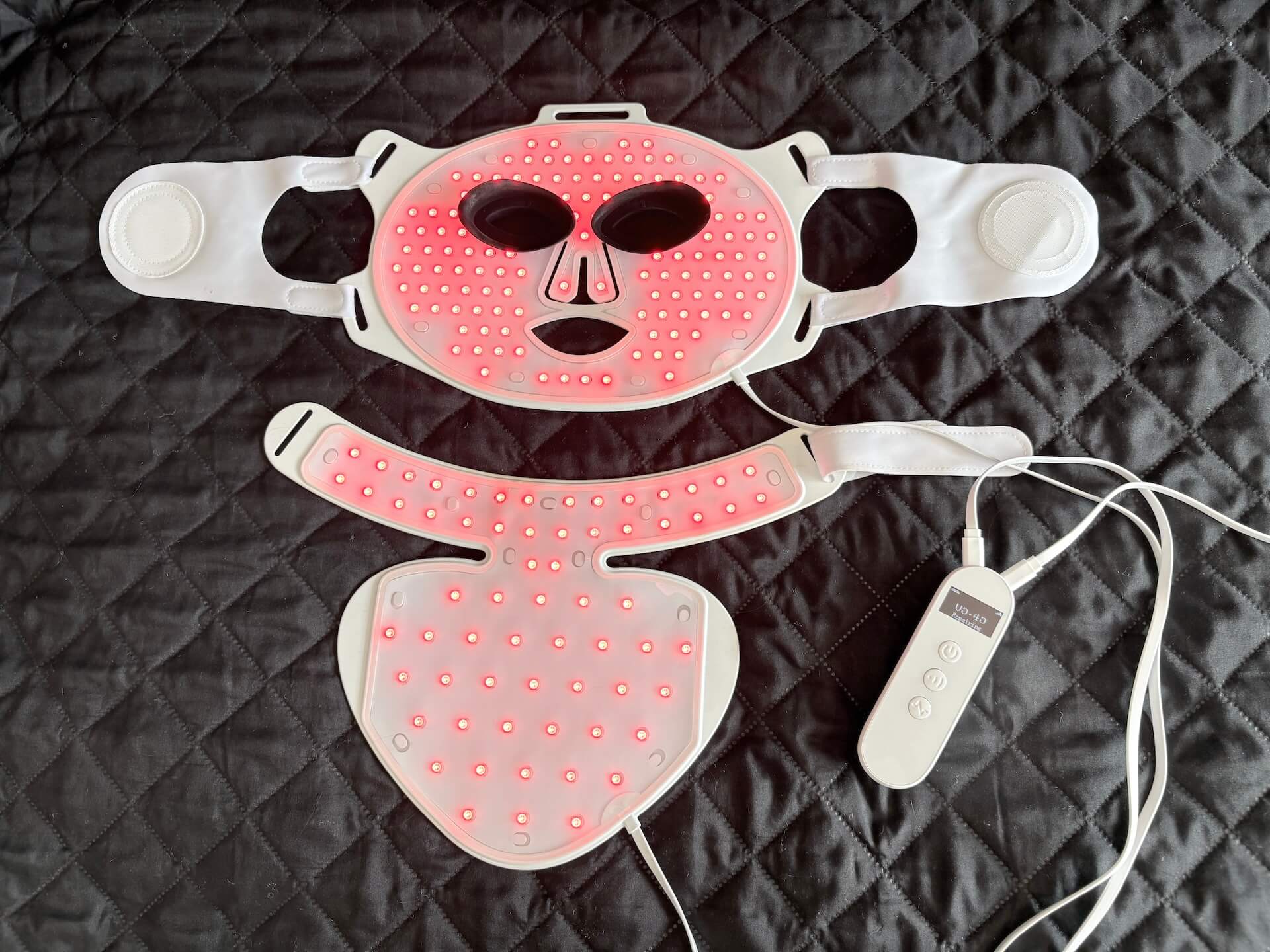 Ansigtsmaske og brystmaske med LED lys fra IVISKIN på seng
