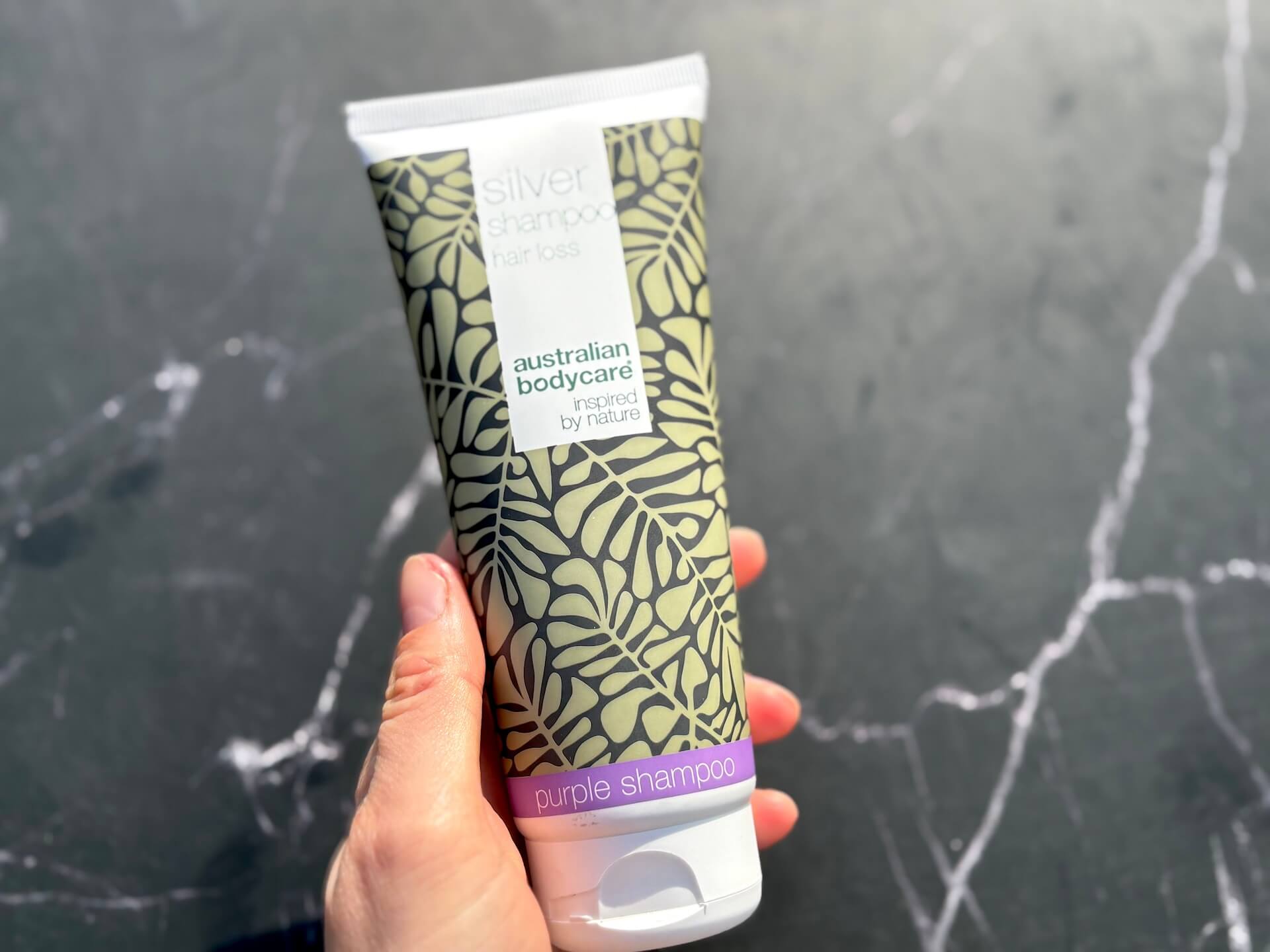 Australian Bodycare Silver Shampoo i hånd på badeværelse