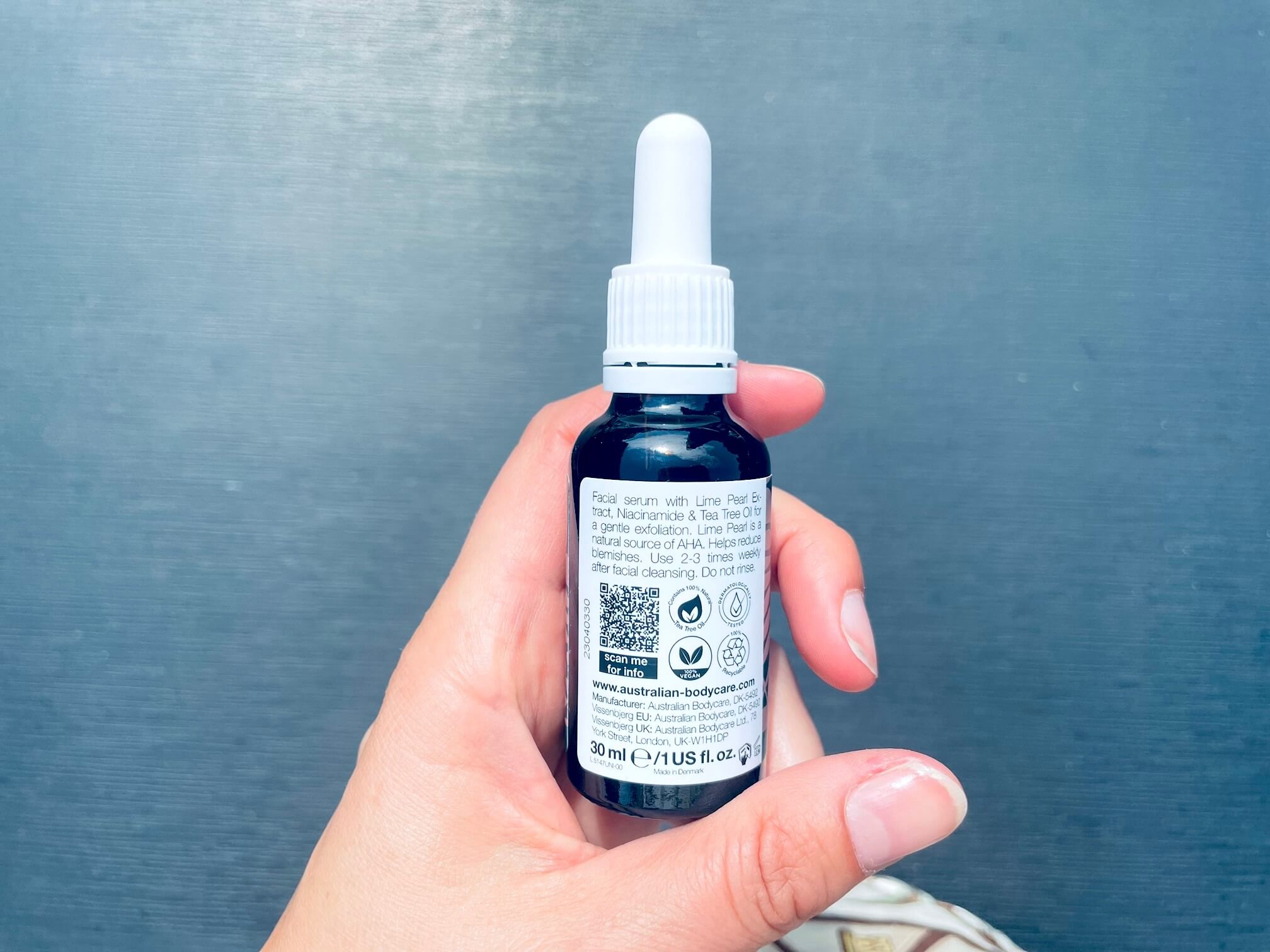 Bagside af Peeling Serum fra Australian Bodycare i hånd