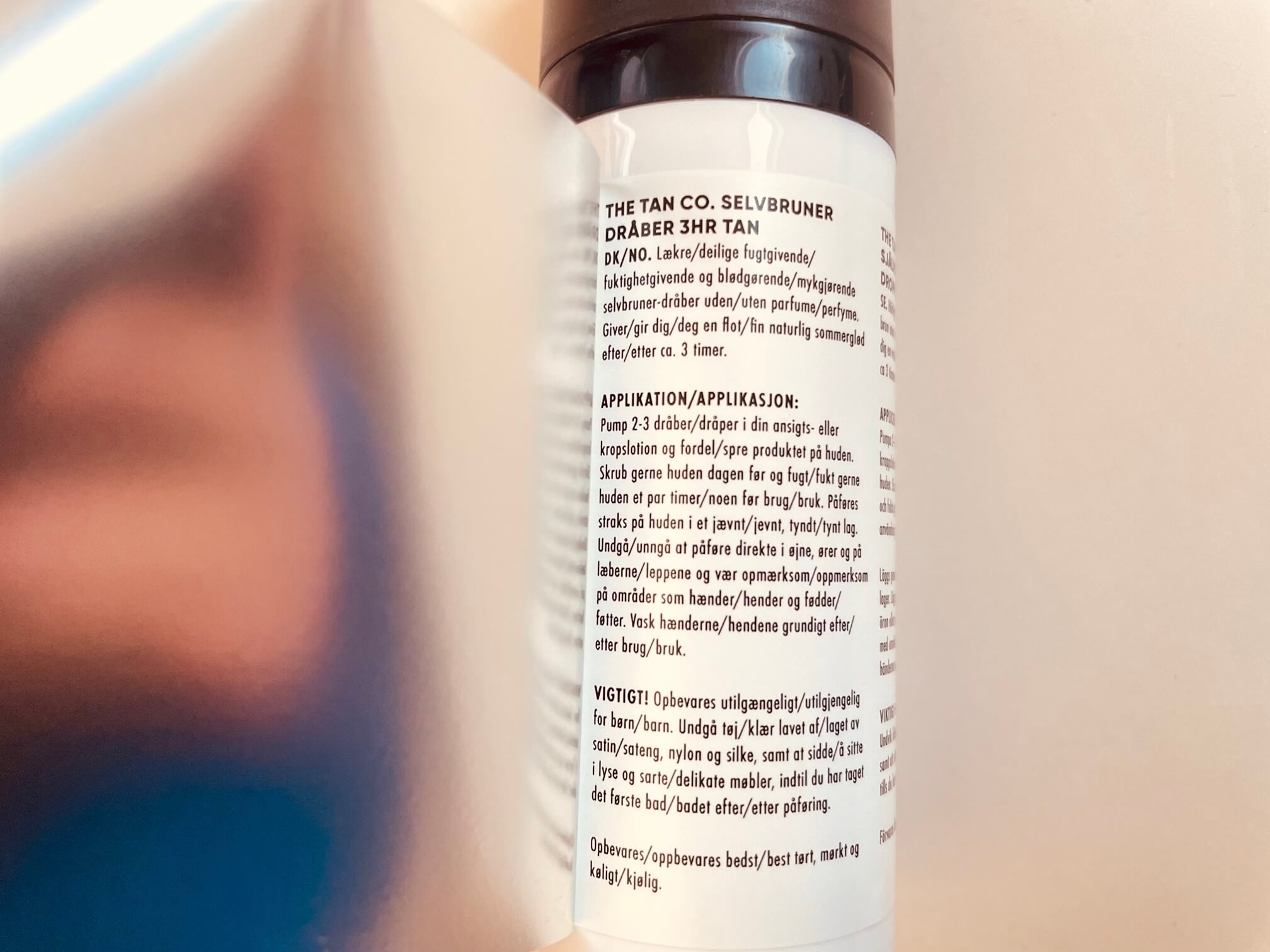Bagside med instruktioner på The Tan Co. Selvbruner Dråber