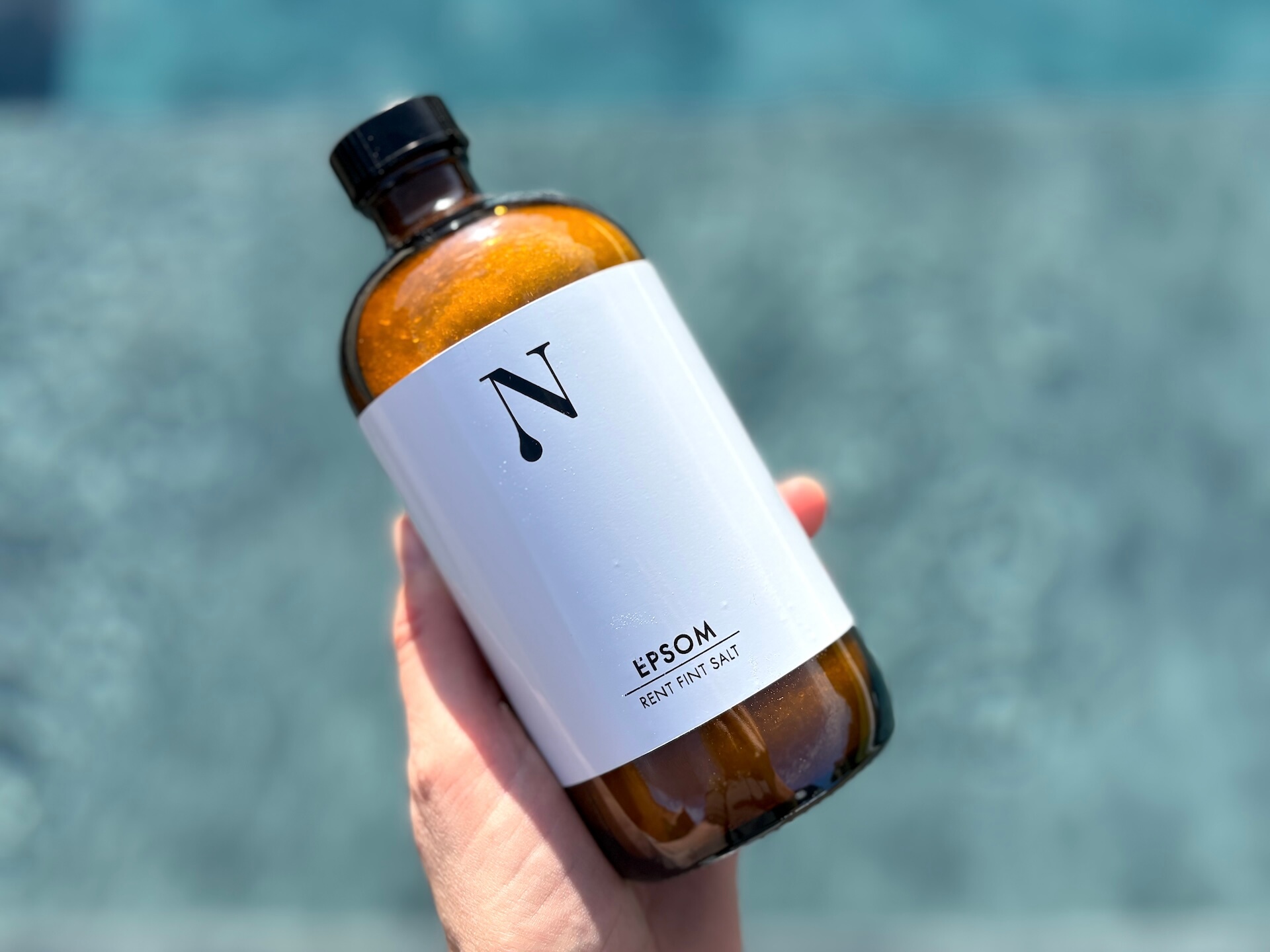 Beholder med Naturligolie Epsom Salt i hånd