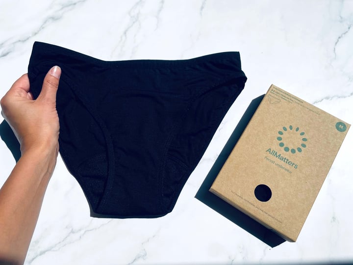 Bikini AllMatters menstruationstrusse i hånd med kassen ved siden af