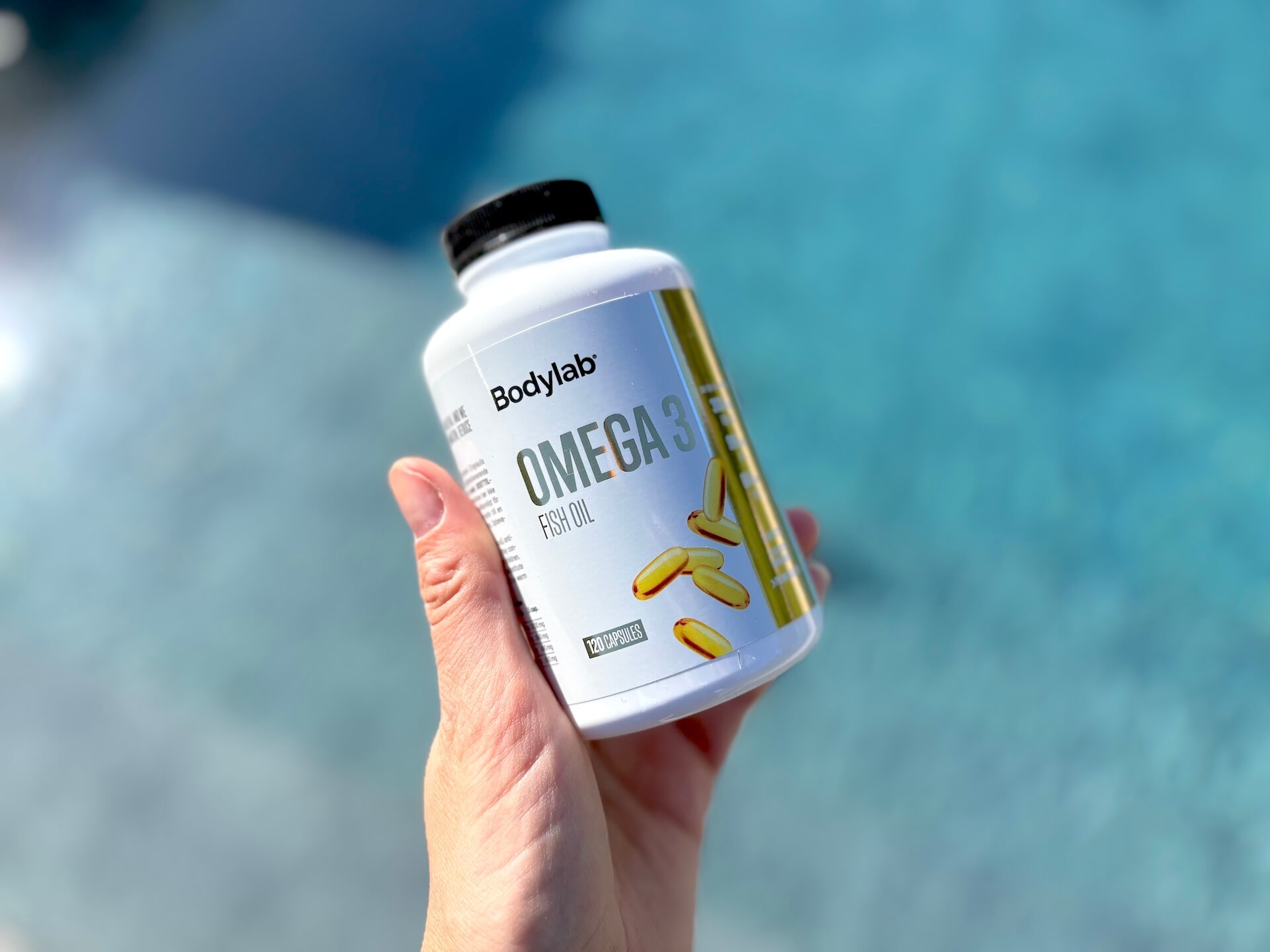 Bodylab Omega 3 300mg i bøtte i hånd over pool