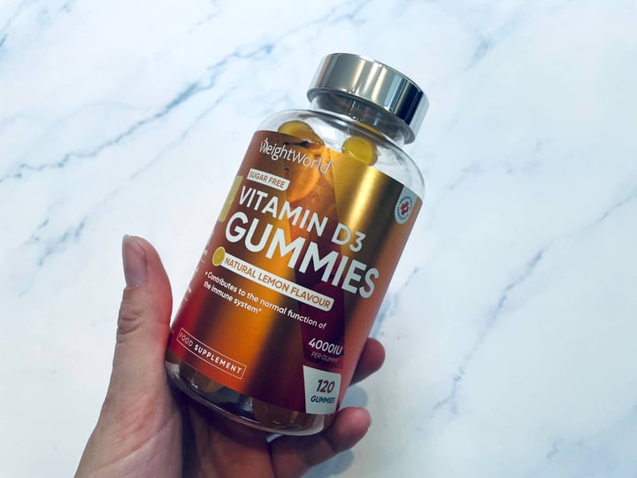 Bøtte med D3-Vitamin Gummies i hånd