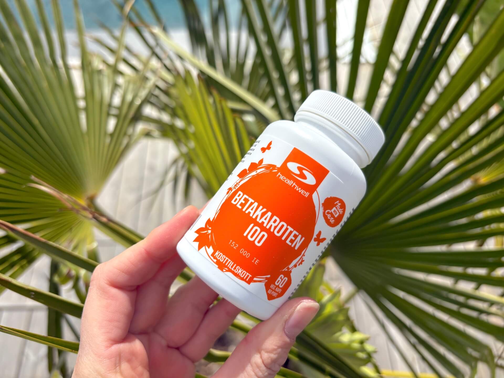 Bøtte med Healthwell Betacaroten 100 i hånd