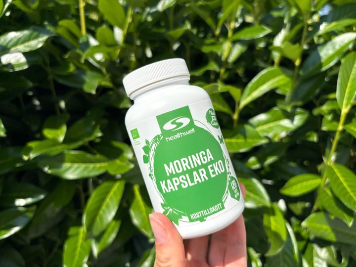 Bøtte med Healthwell Moringa Kapsler ØKO i hånd