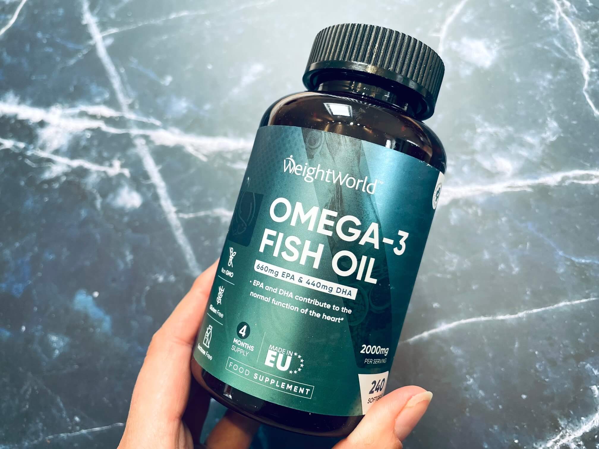 Bøtte med Weightworld Omega-3 Fiskeolie 2000mg i hånd