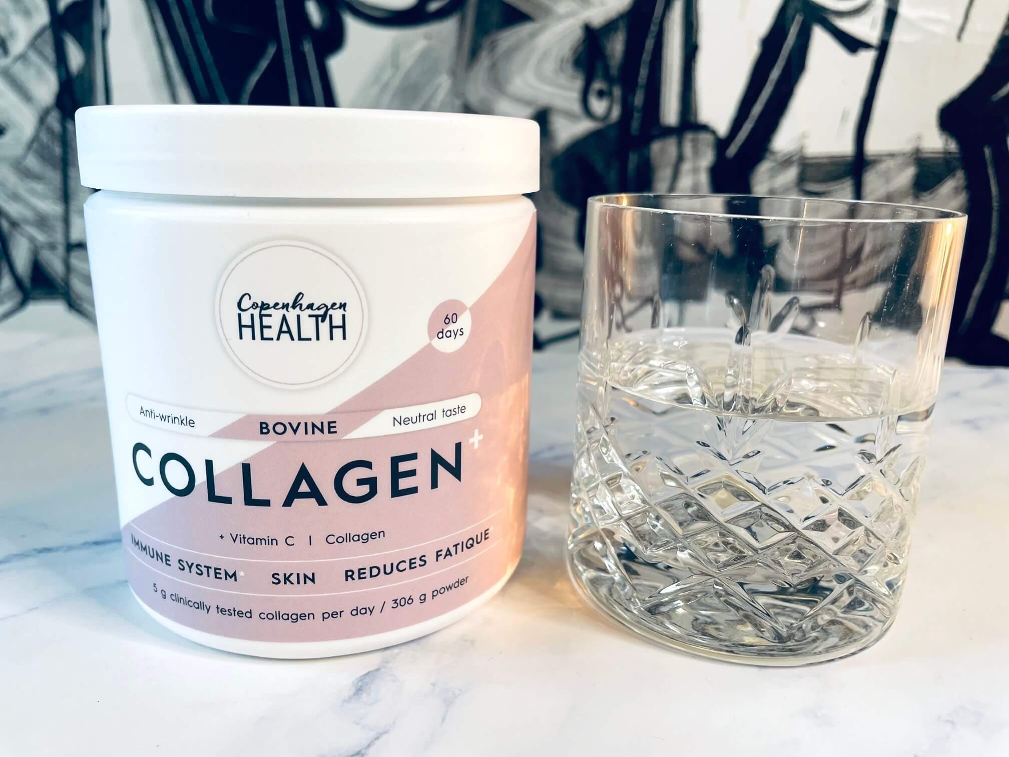 Bovine Collagen+ ved siden af et glas vand