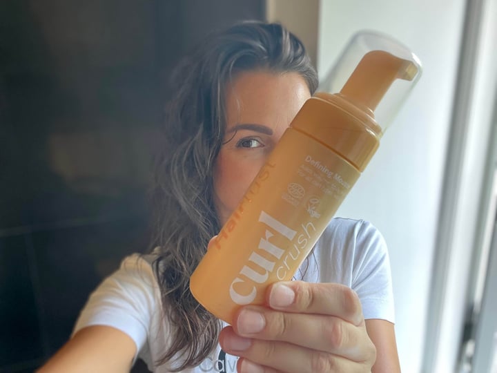 Curl Crush Defining Mousse fra Hairlust i hånd på kvinde