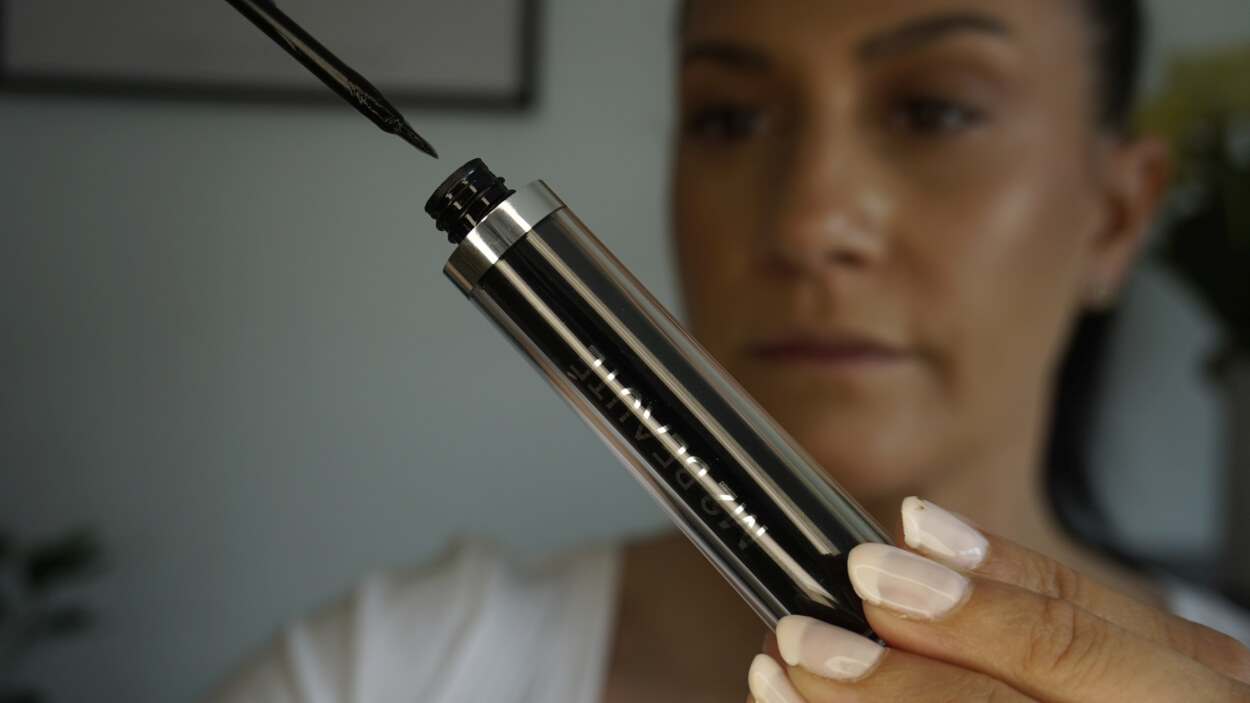 Kvinde holder M2 øjenvippeserum
