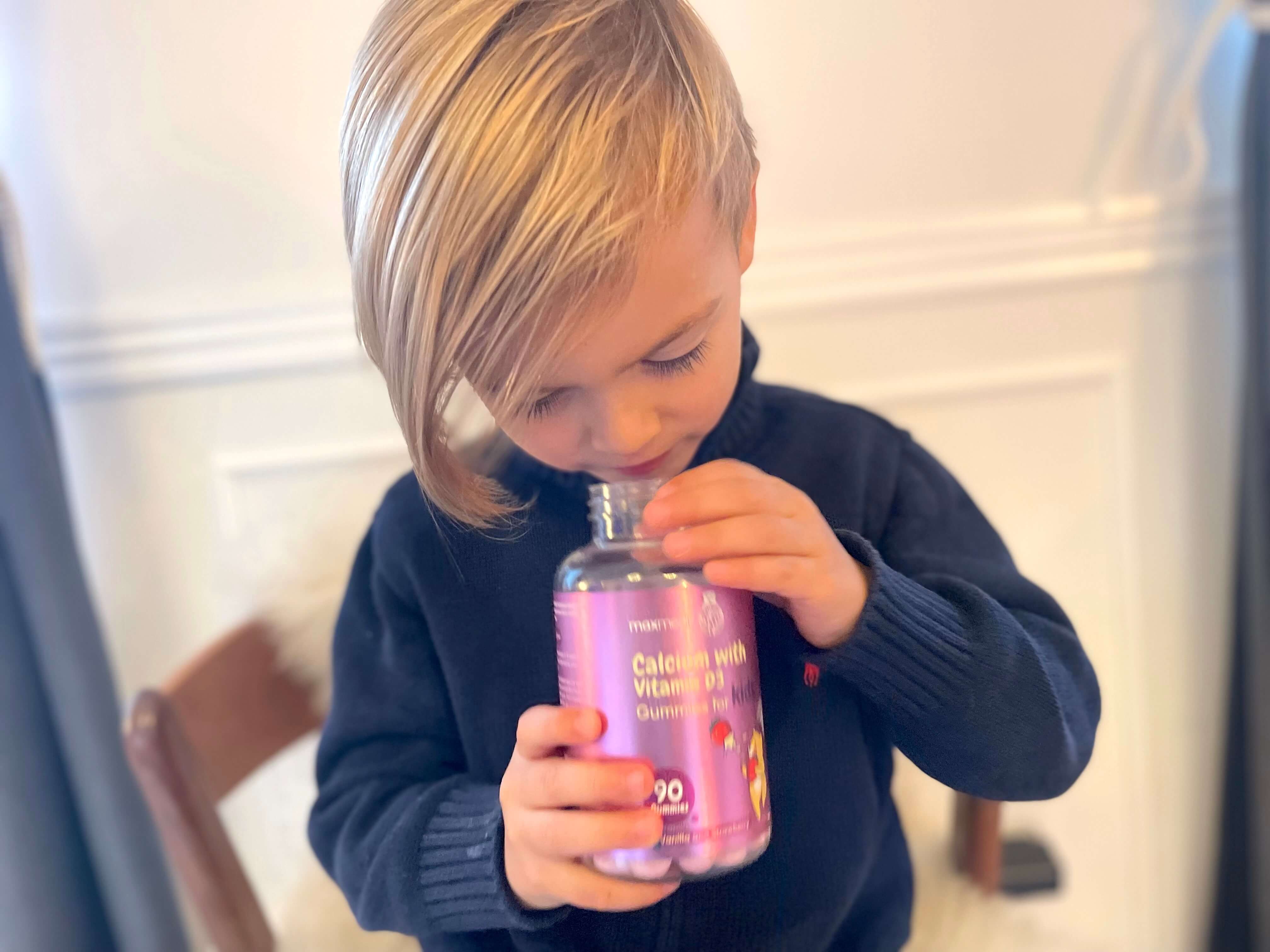 Dreng der kigger ned i bøtte med kalk og D3 vitamin vingummier
