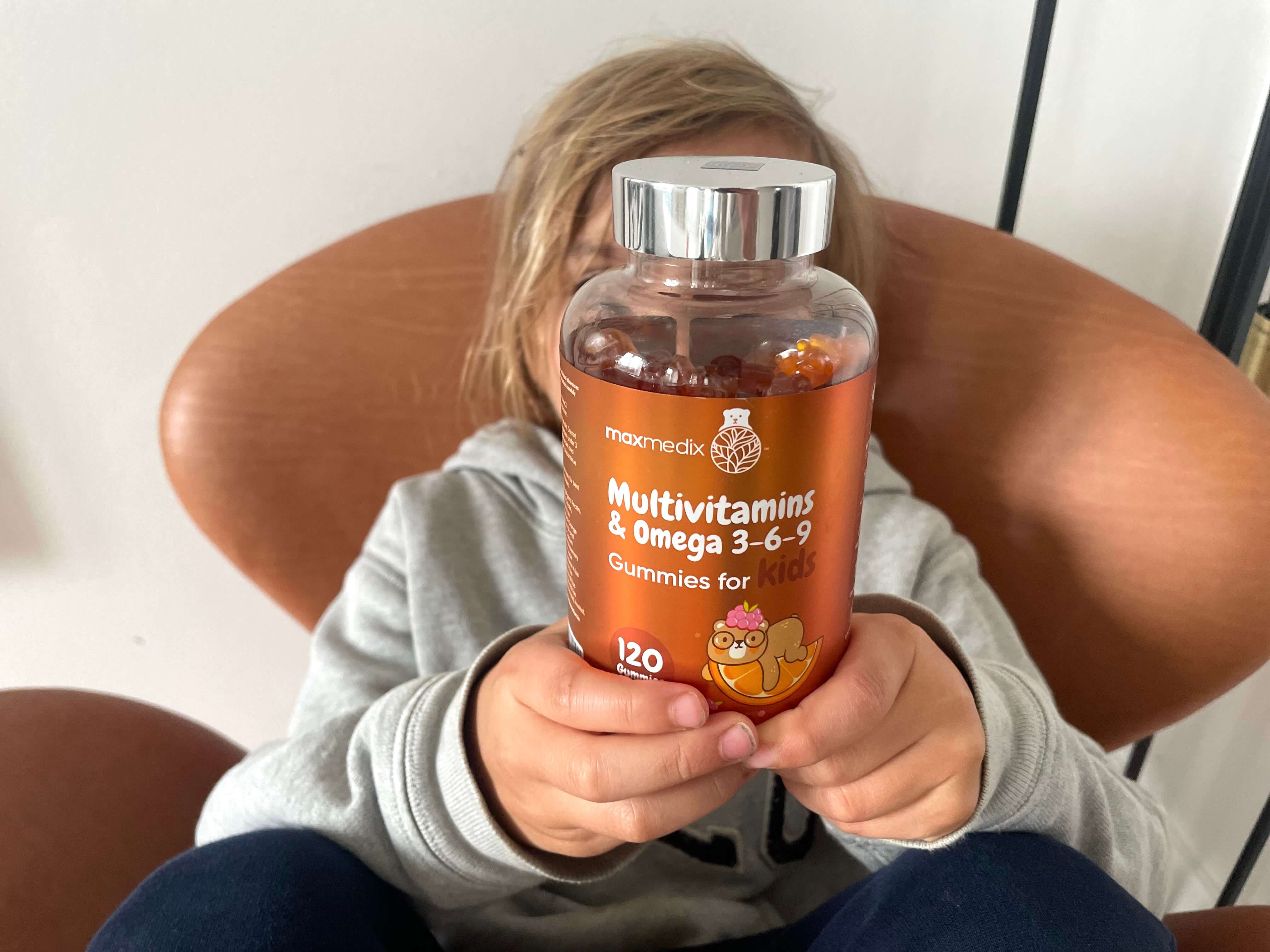 Dreng der sidder med Maxmedix Multivitamins & Omega 3-6-9 gummies for kids