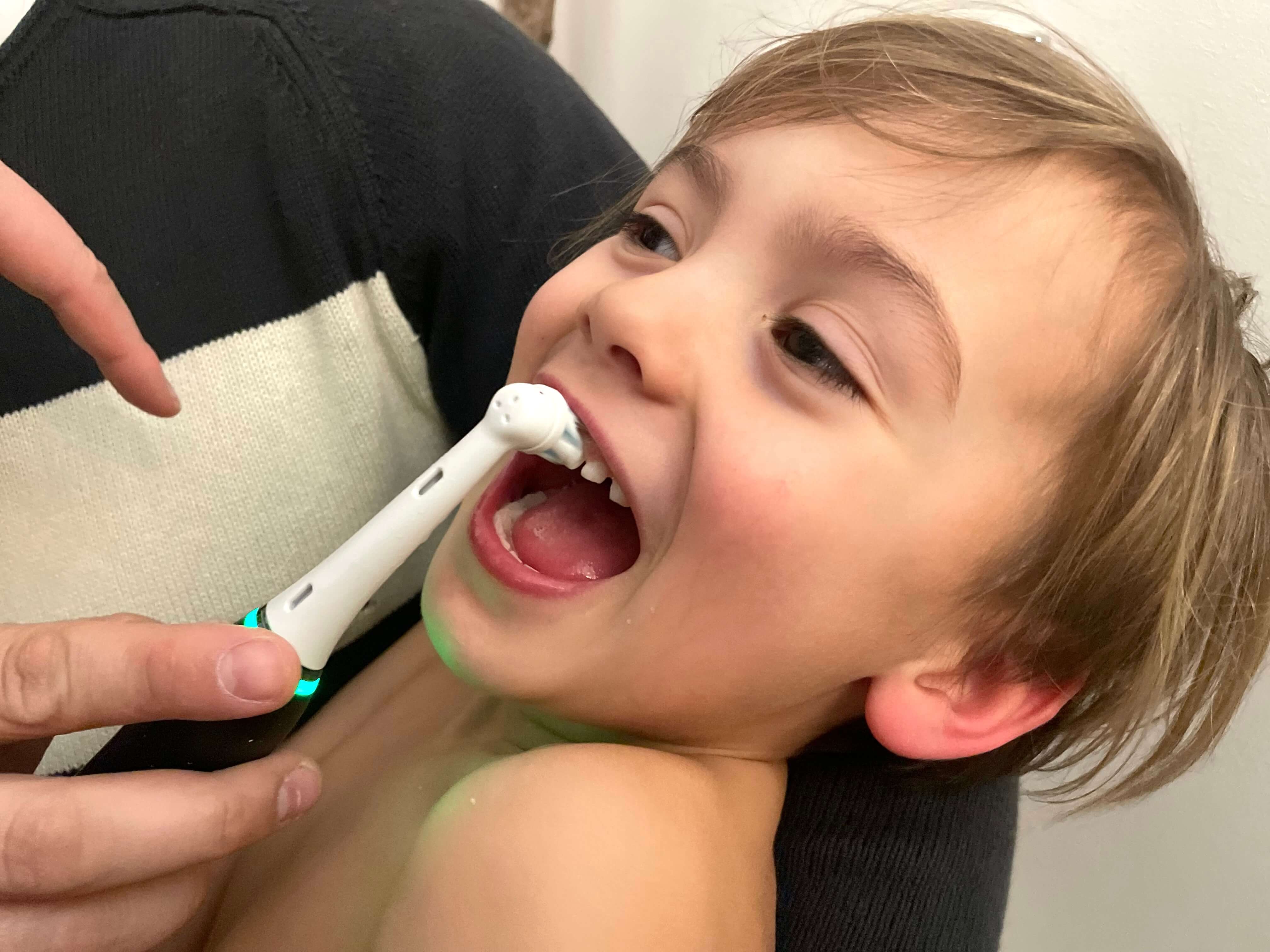 Dreng der smiler og får børstet tænder med iO 10