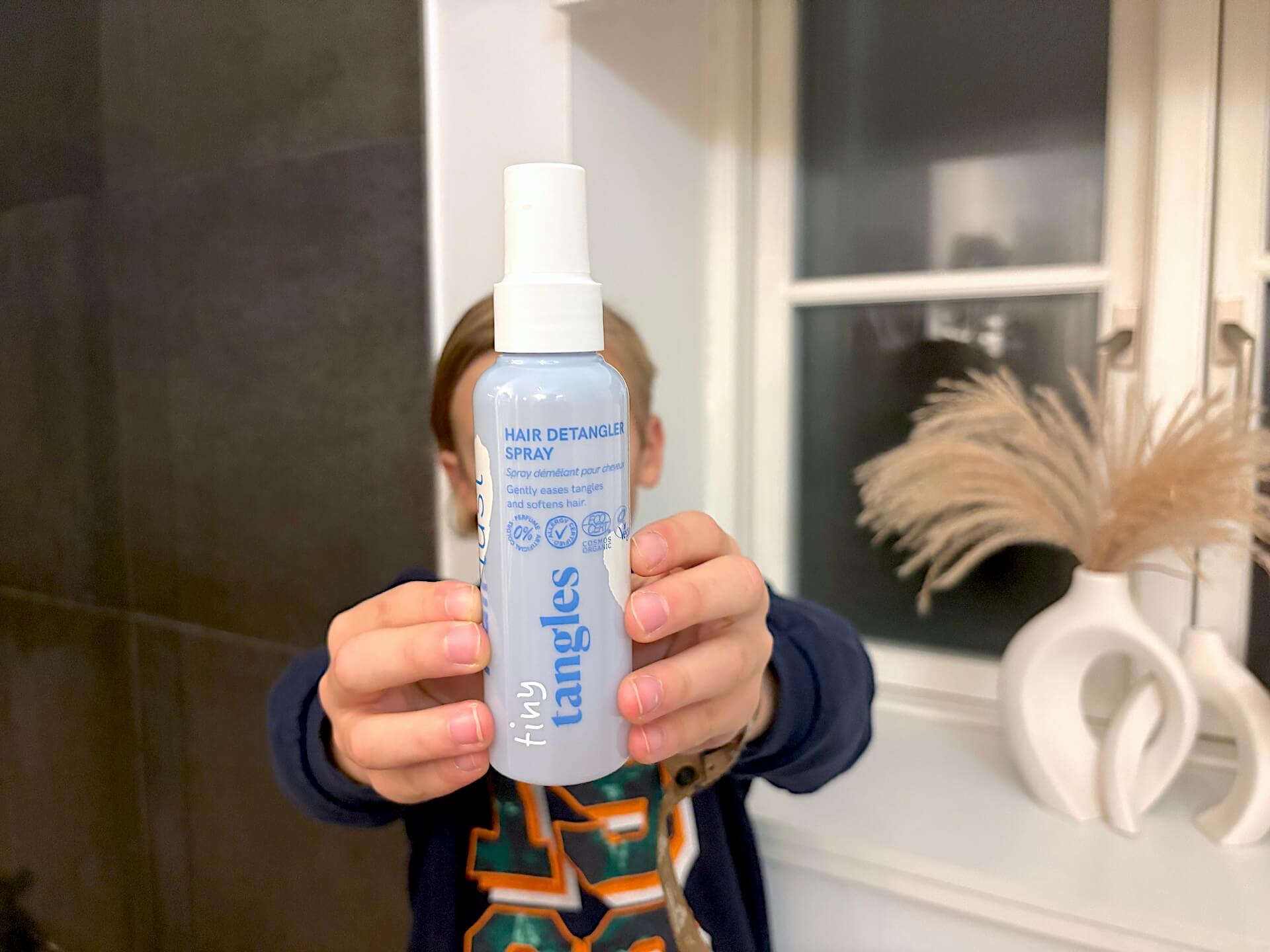 Dreng der står med Hairlust Tiny Tangles Hair Detangler Spray