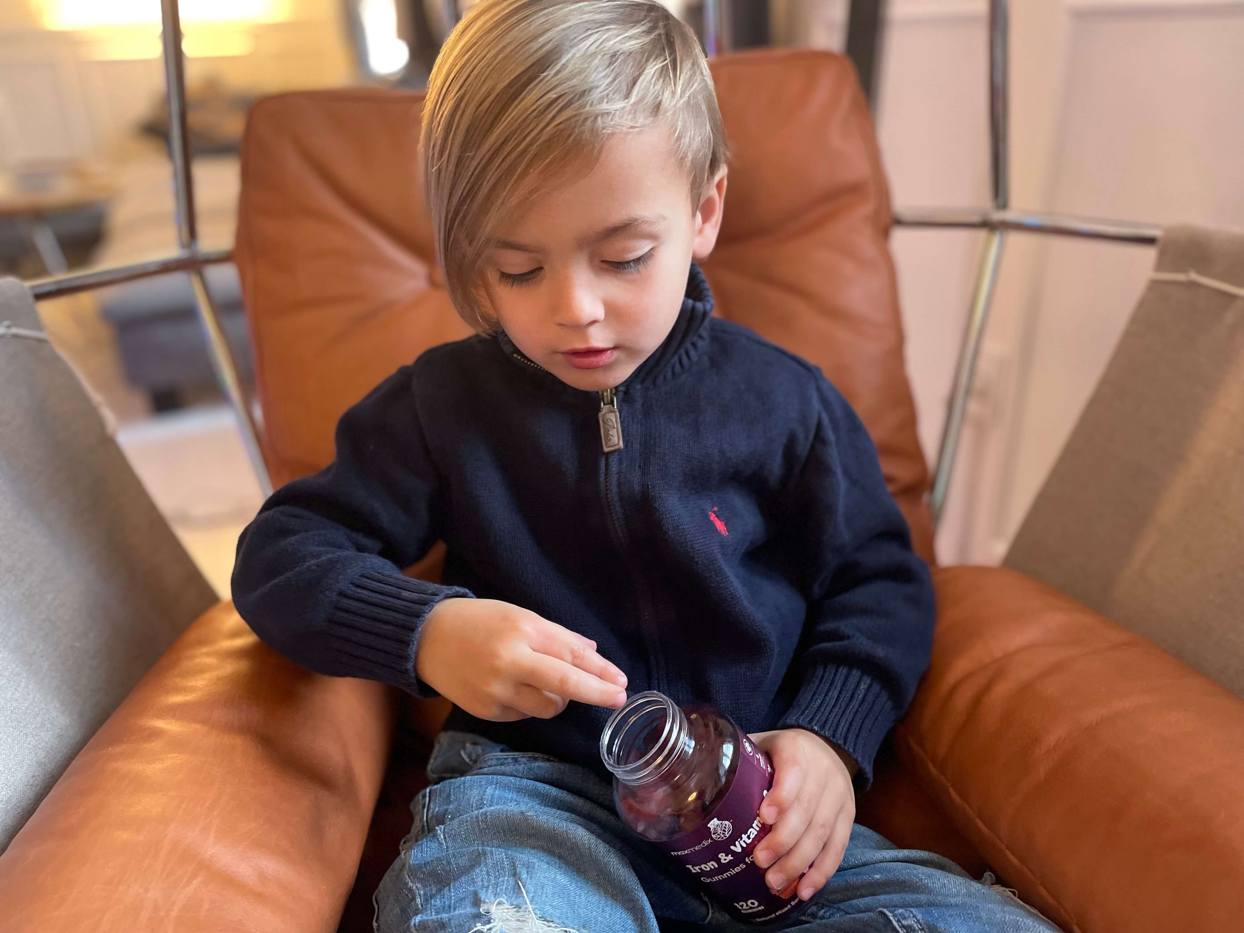 Dreng sidder med Jern og C-vitamin vingummier til børn