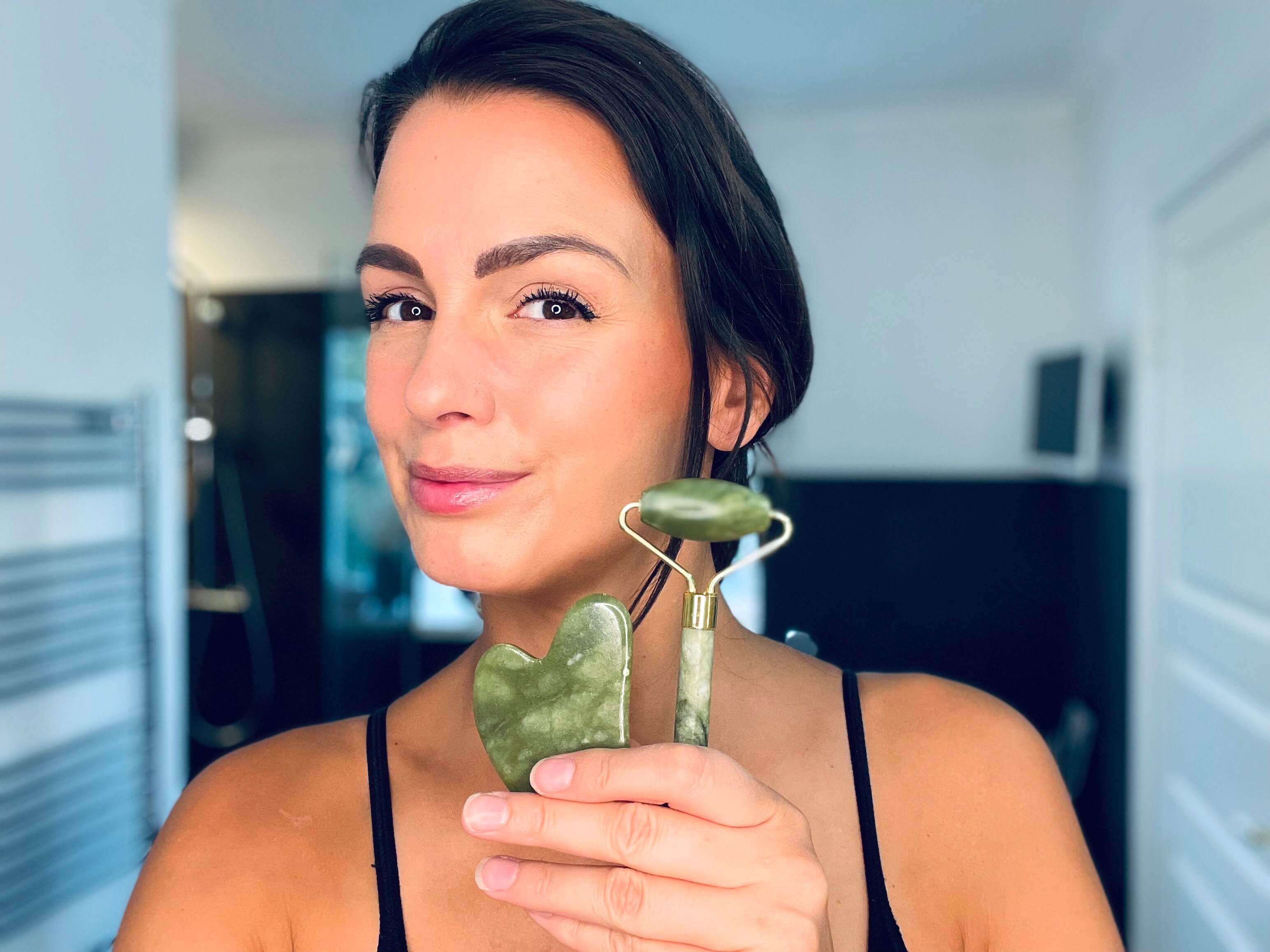 Eco Masters grøn jade roller med gua sha sten i hånd på kvinde