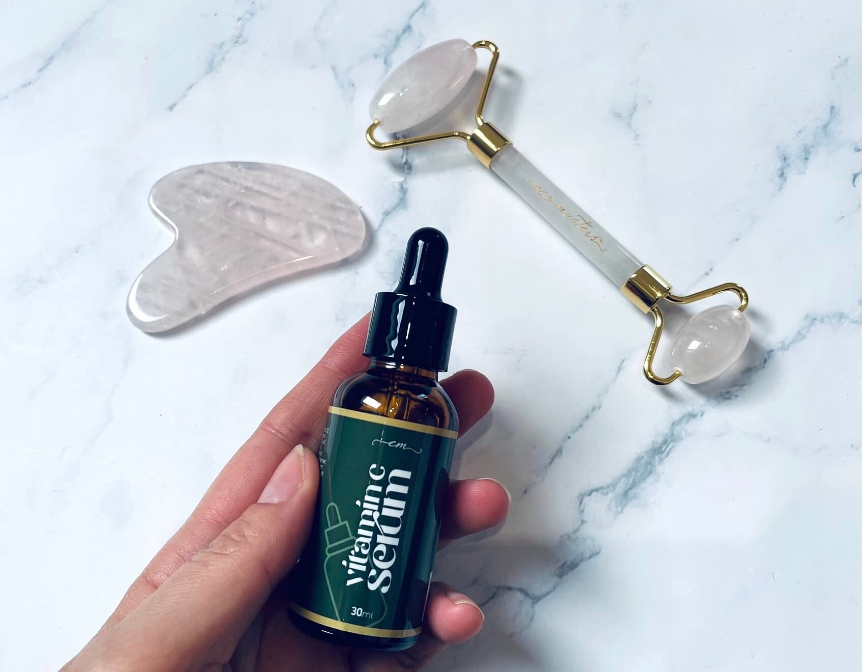 Eco Masters rose quartz gua sha sten & jade roller med serum i hånd