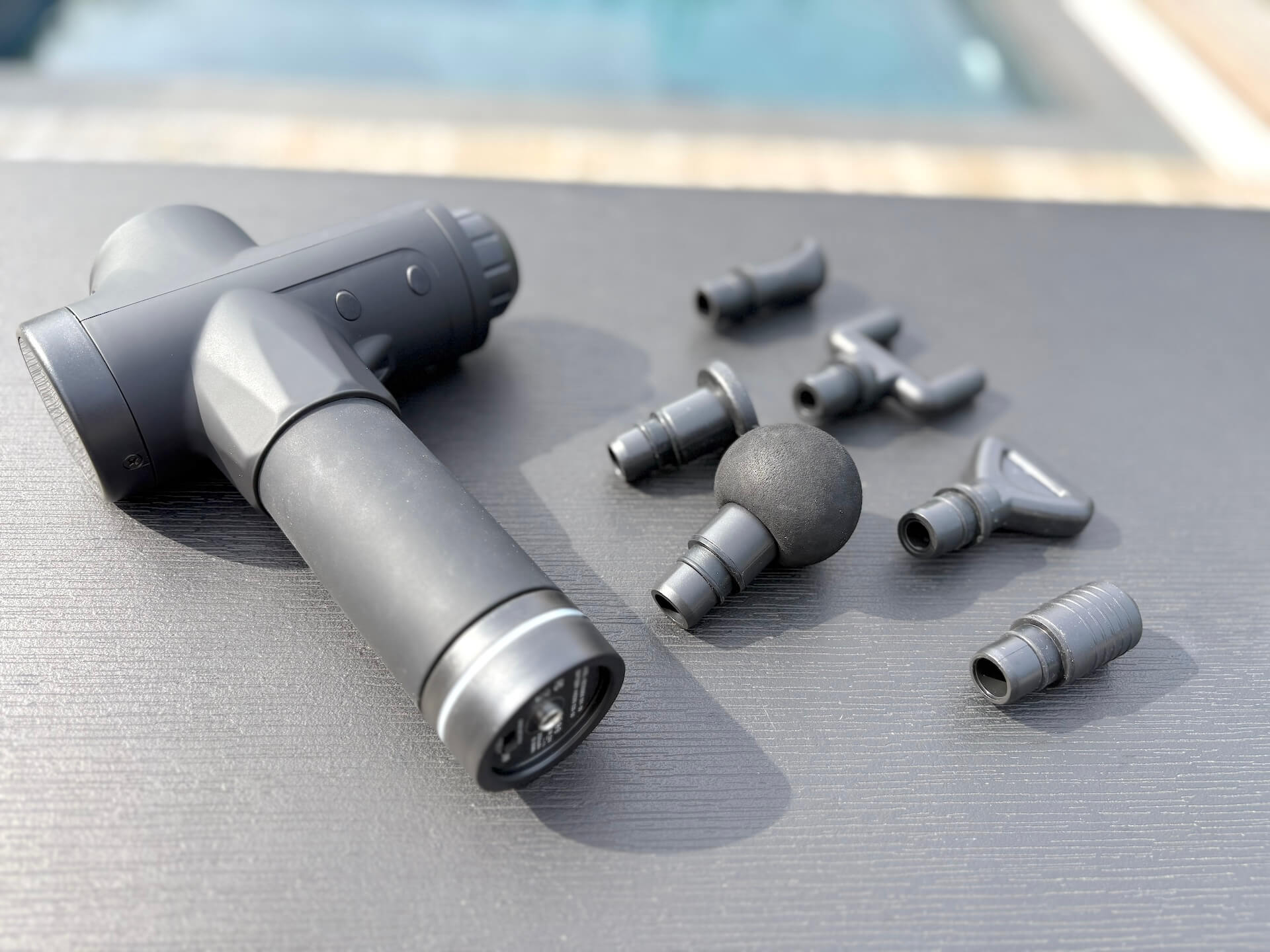 Fitnessfree Massagepistol PRO på bord med 6 hoveder