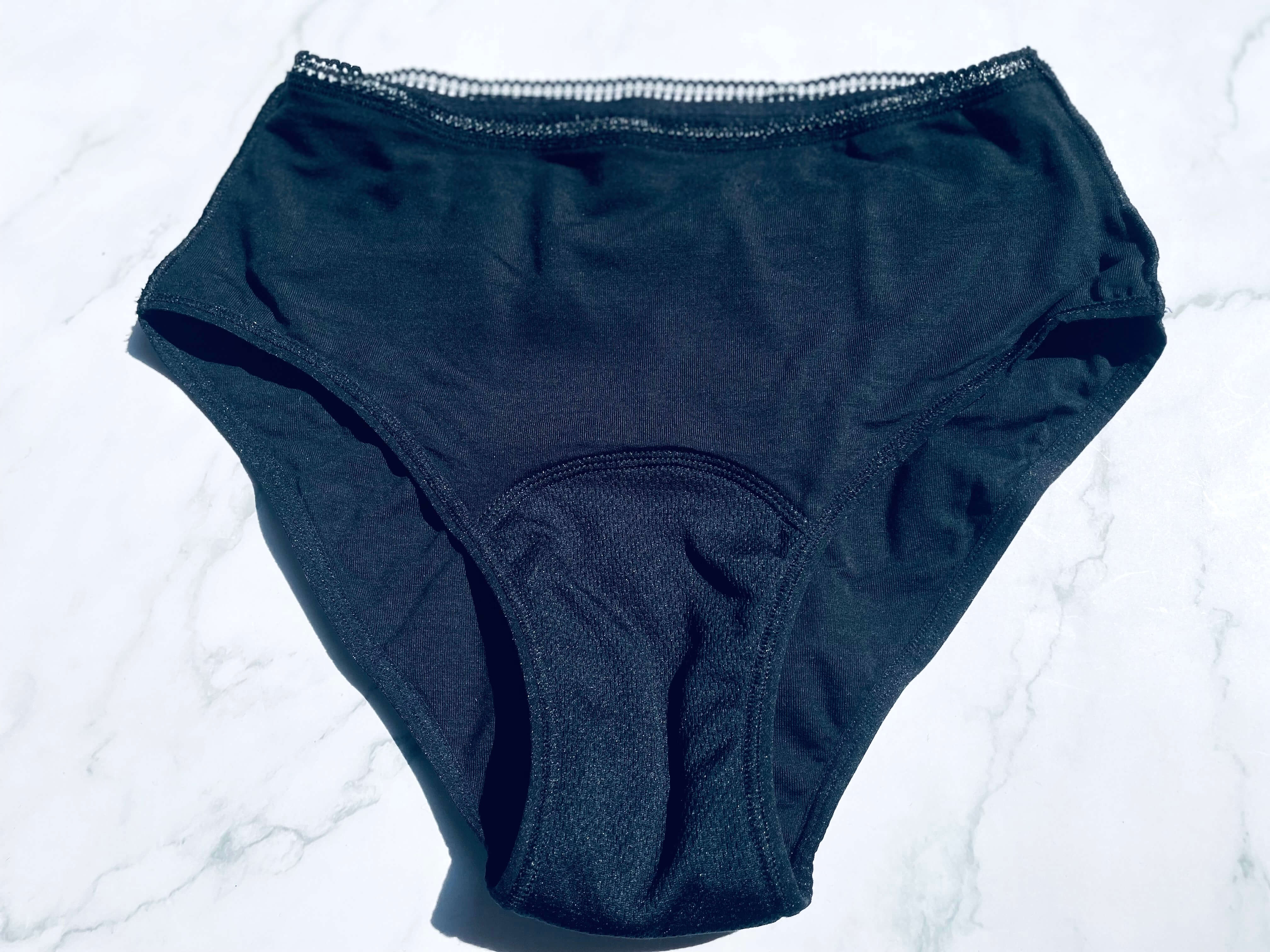 Fronten af AllMatters menstruationstrusse der ligger på bord