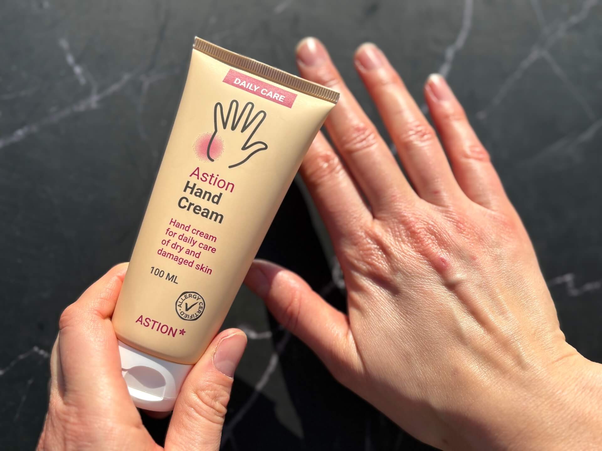 Hånd der er smurt med Astion Hand Cream