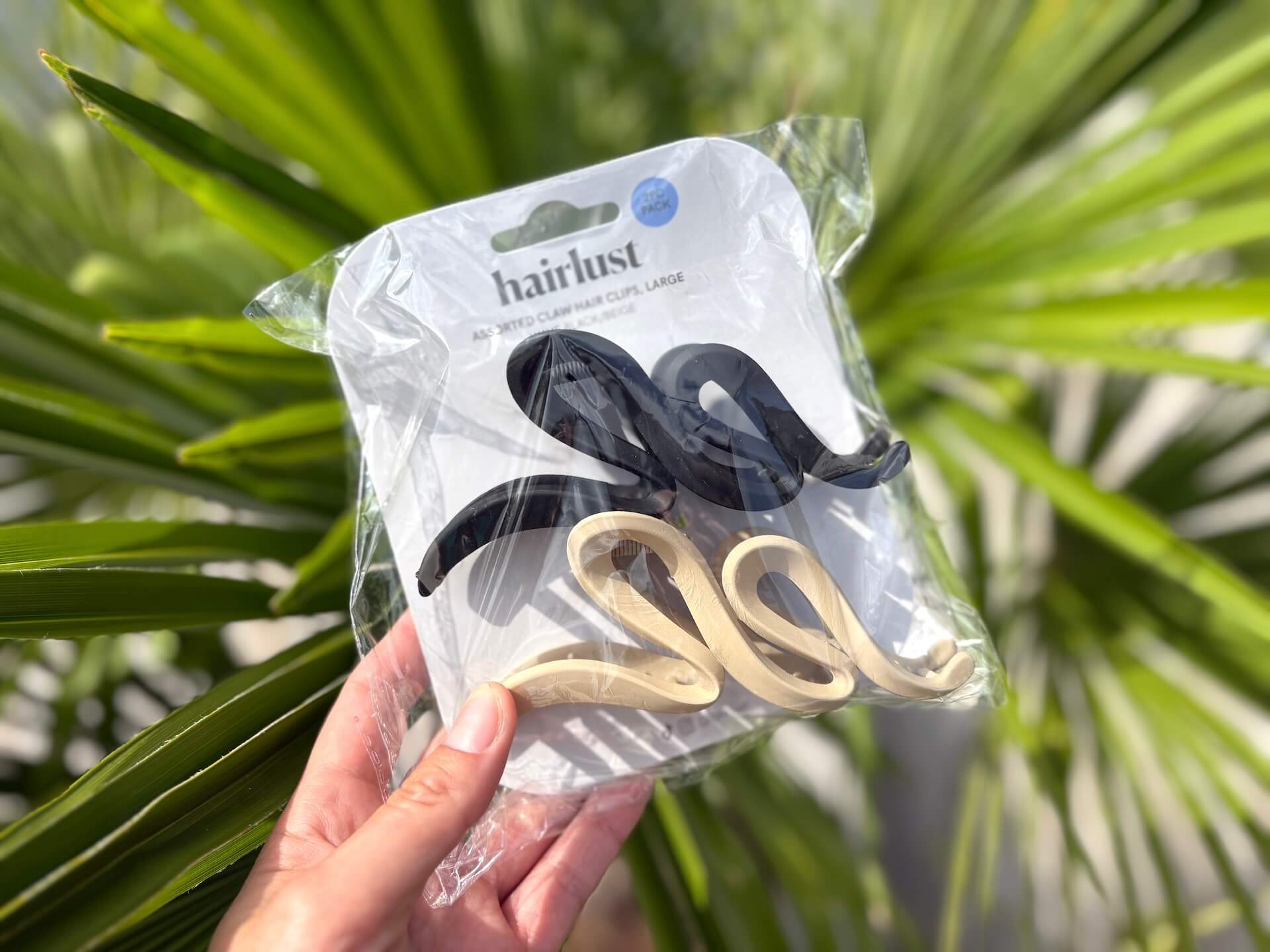 Hånd med uåbnet Hairlust Large Claw Hair Clips Wave 2 Pack