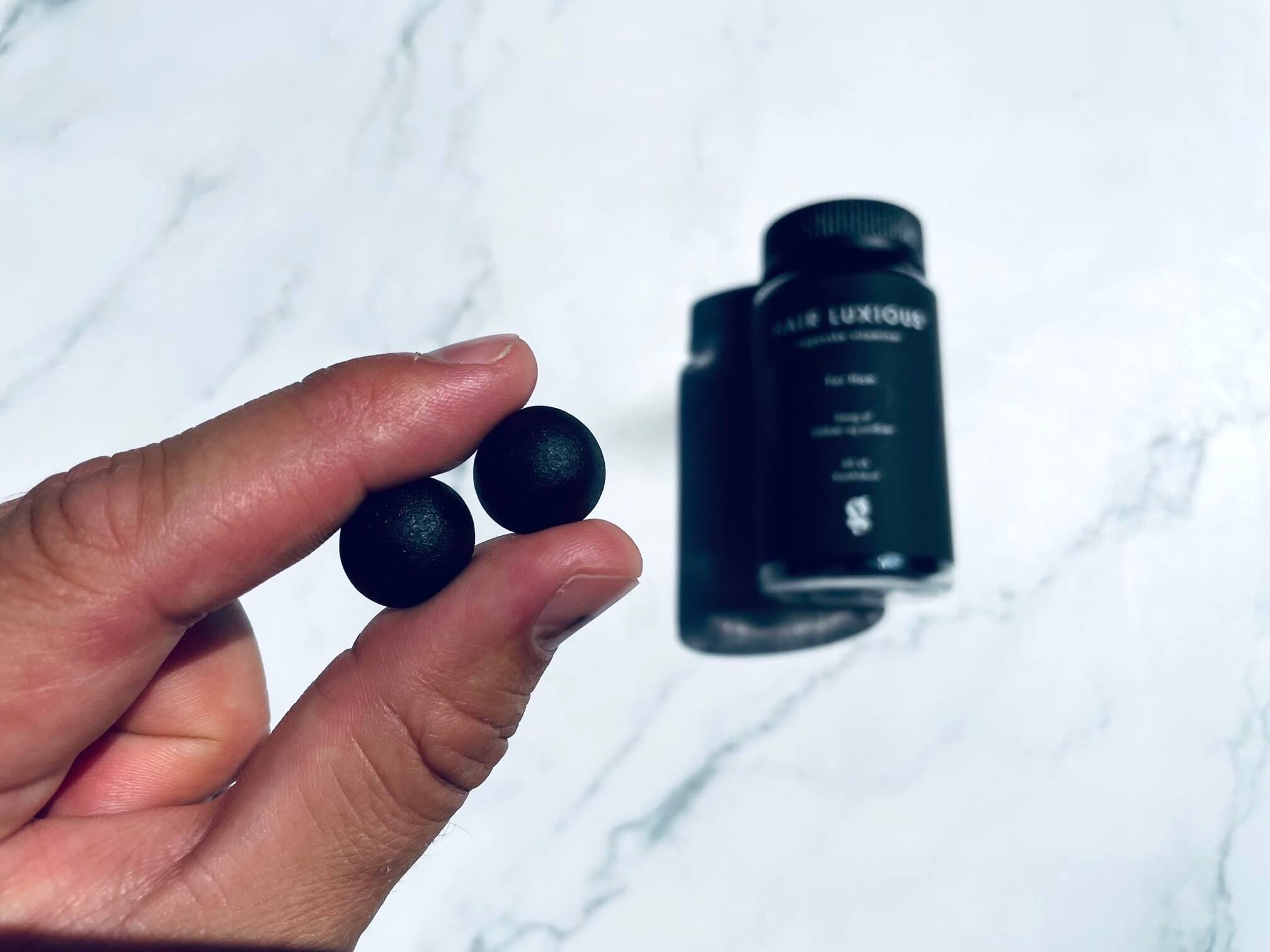 Hårvitaminer til mænd i mellem fingrene på mand fra Good For Me