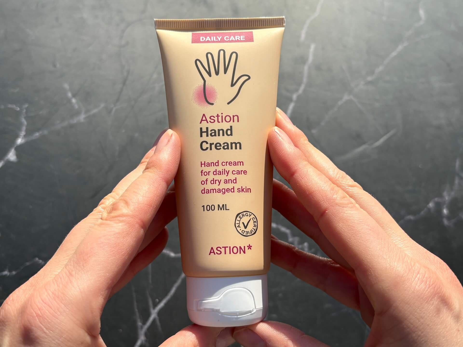 Hænder der holder Astion Hand Cream