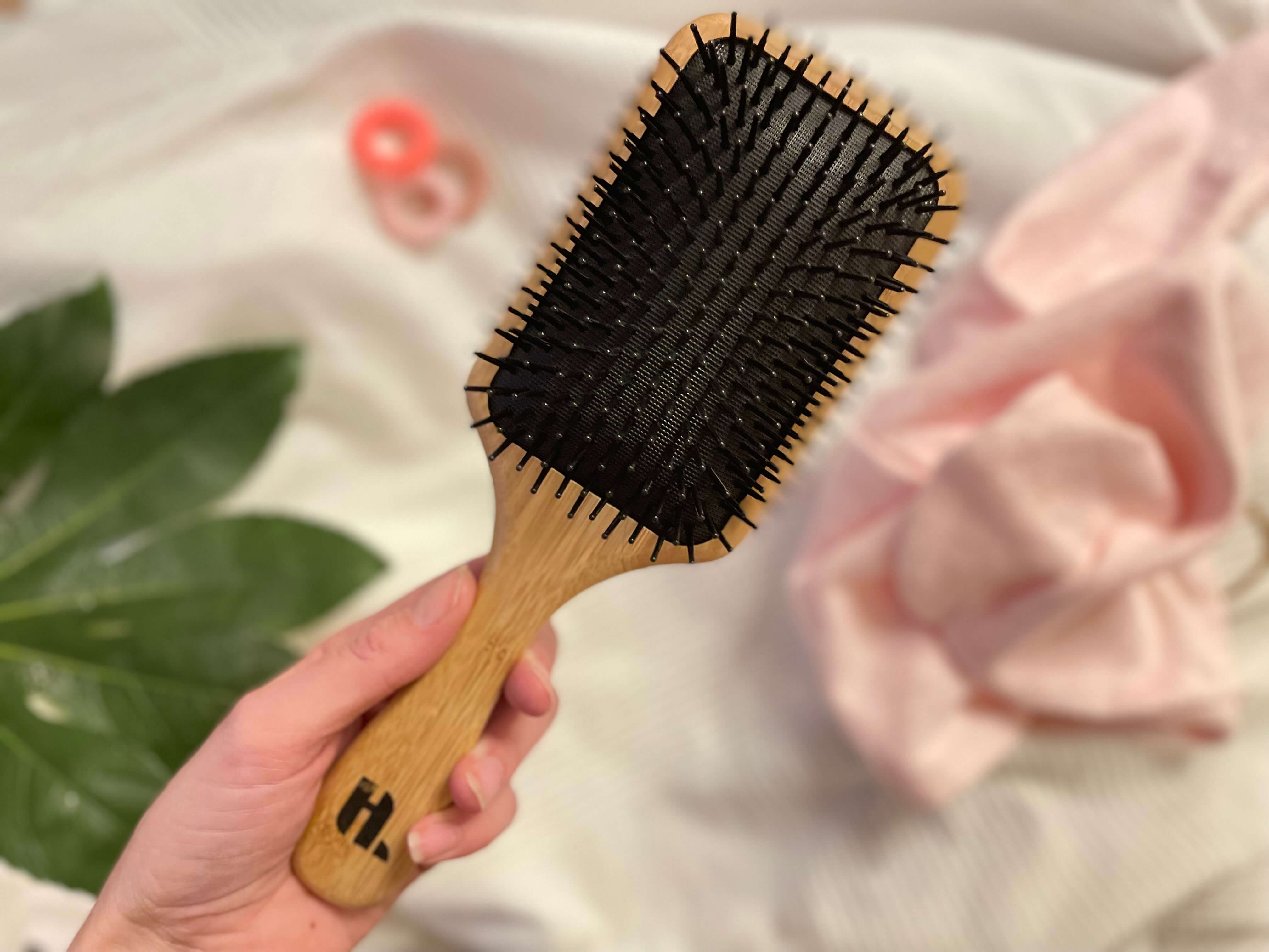 Hairlust Bamboo pladebørste i en hånd