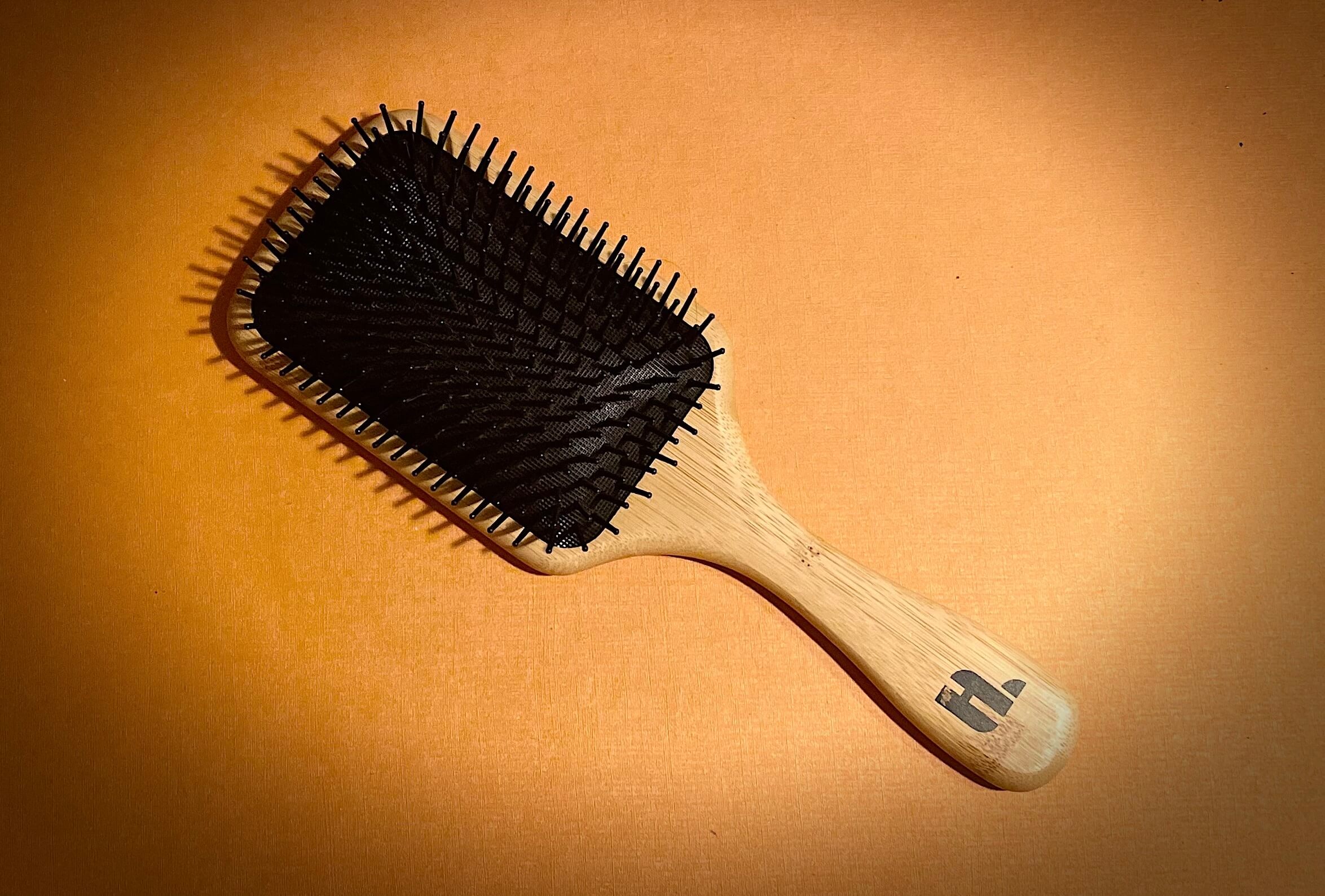 Hairlust Bamboo pladebørste tæt på med orange baggrund