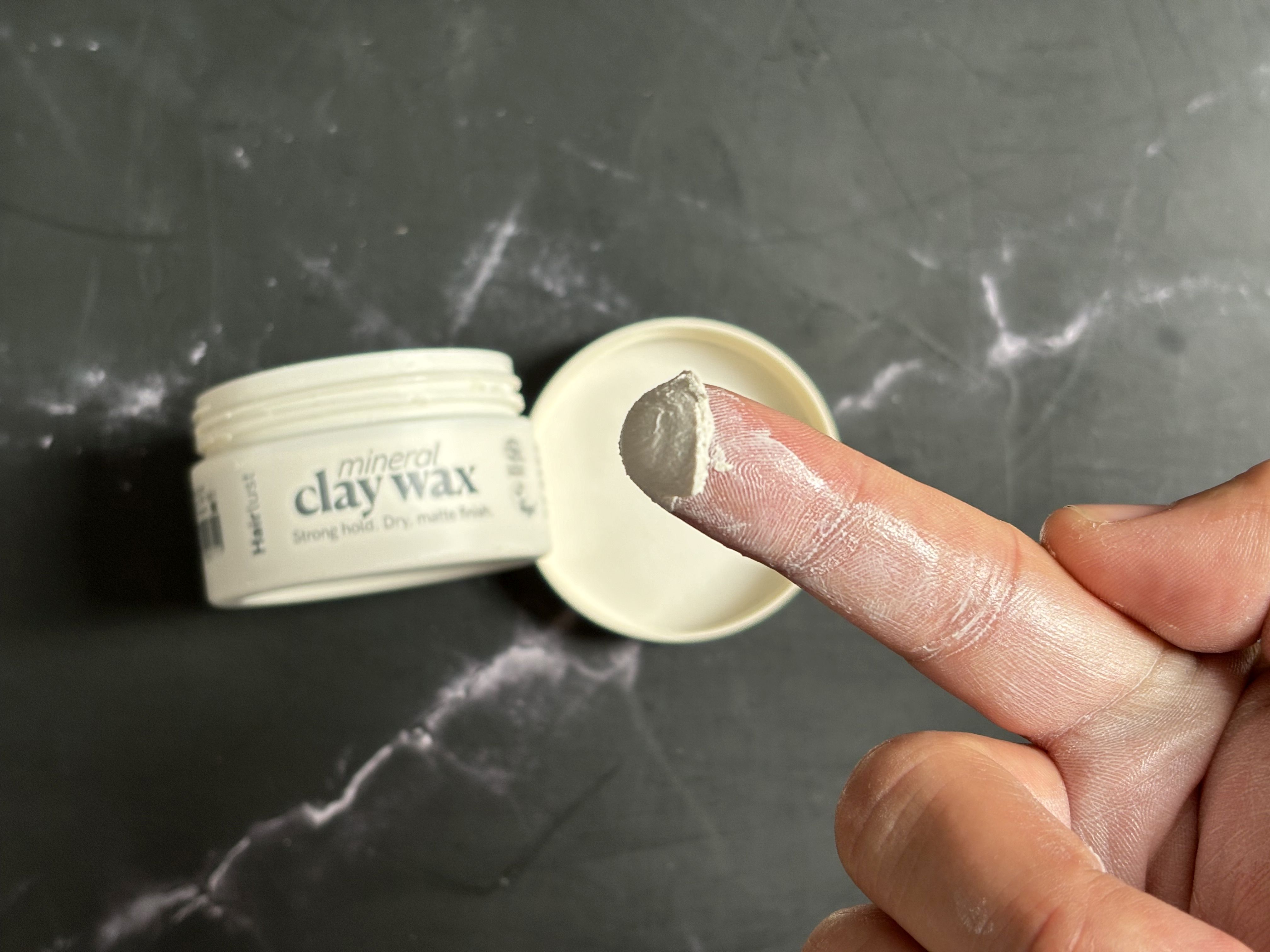 Hairlus clay voks på fingerspids før opvarmning i hænderne