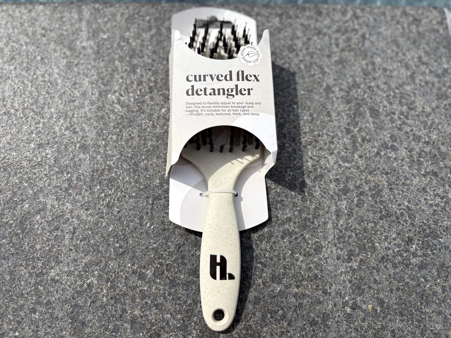 Hairlust Curved Flex Detangler i kasse på flise