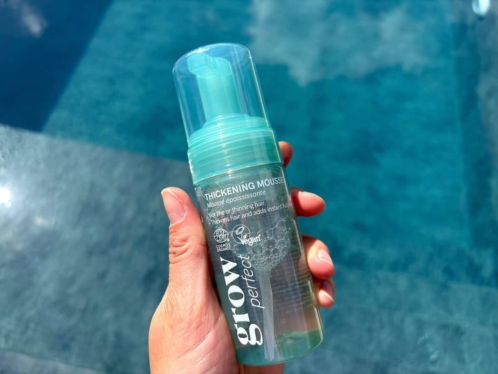 Hairlust Grow Perfect Thickening Mousse i hånd over pool