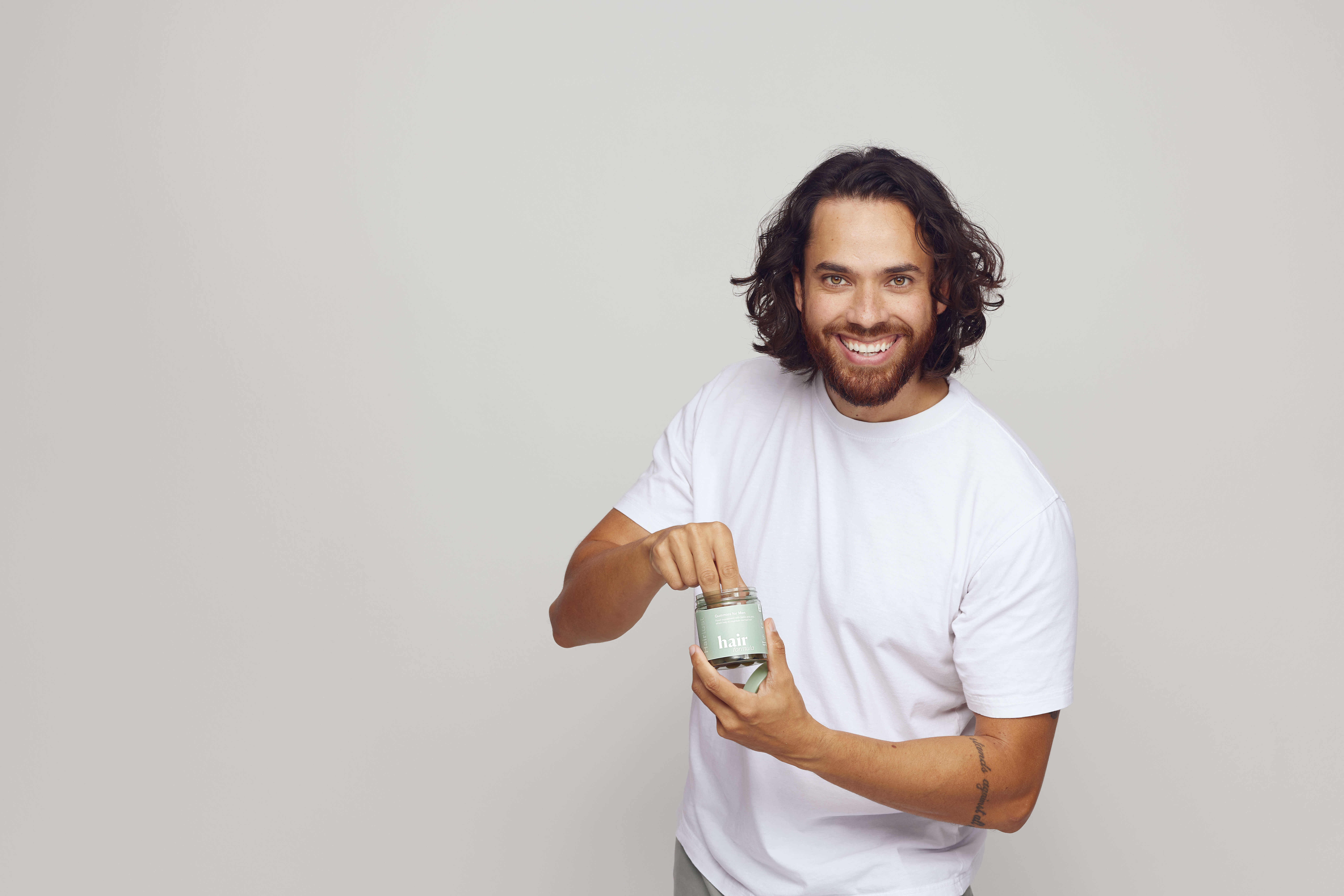 Hairlust Hair Formula Gummies i hånden på en mand