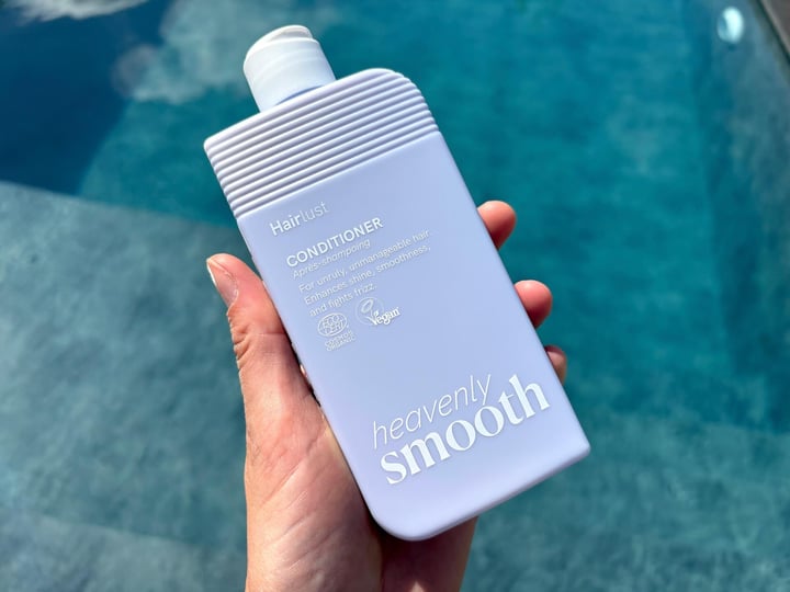 Hairlust Heavenly Smooth Conditioner i hånd over pool