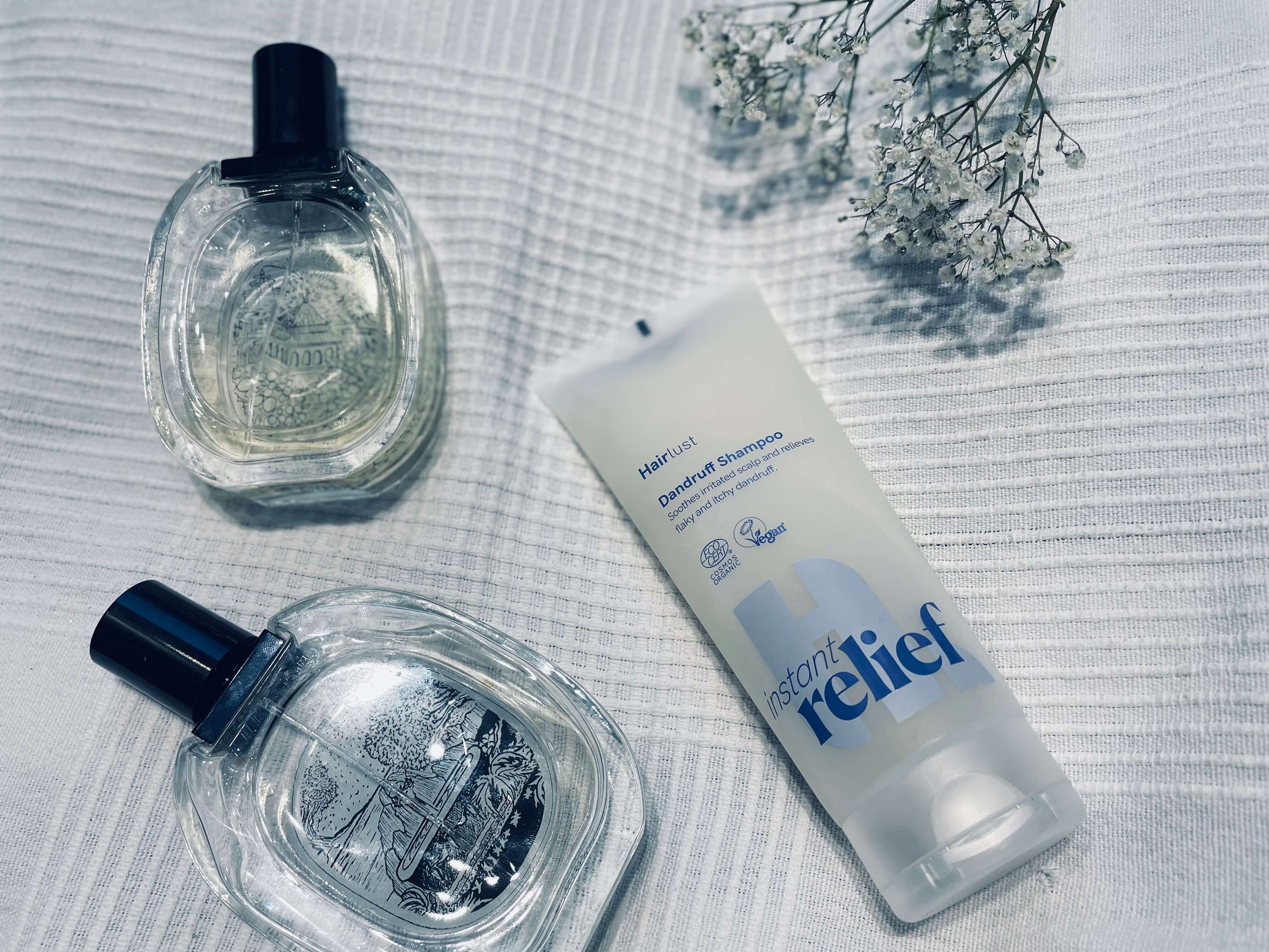Hairlust Instant Relief skælshampoo på en seng