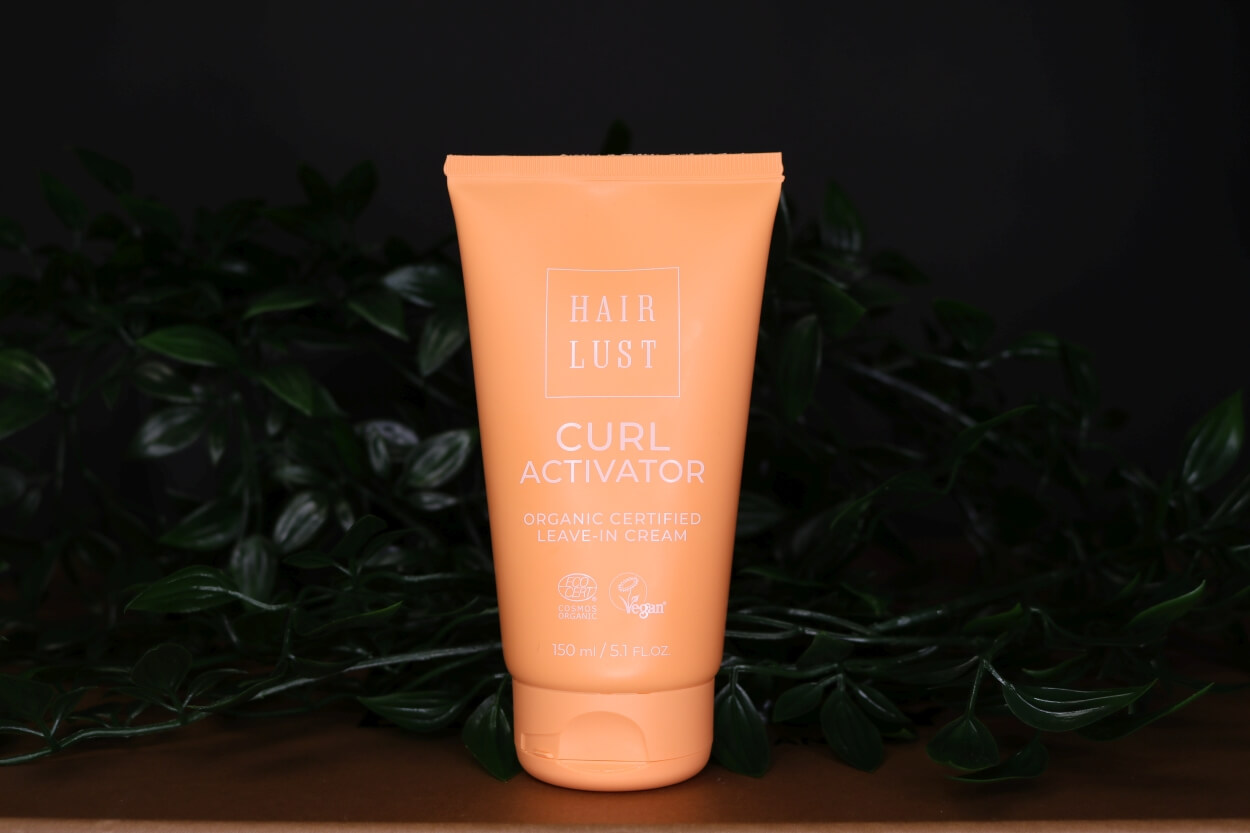 Hairlust krøllecreme foran plante