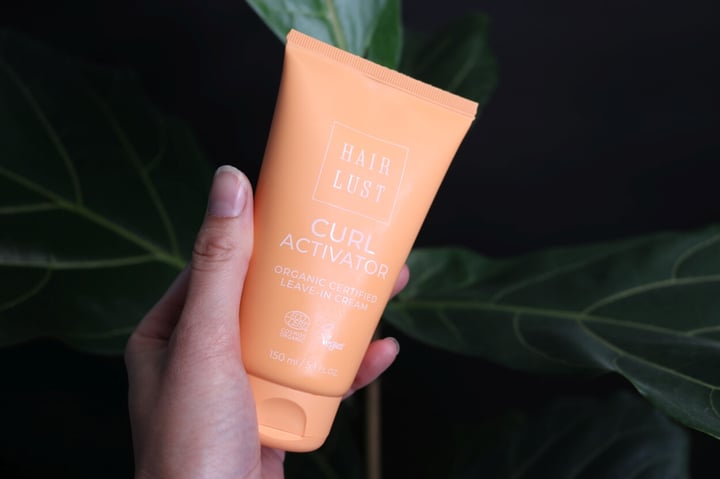 Hairlust krøllecreme holdes i hånden