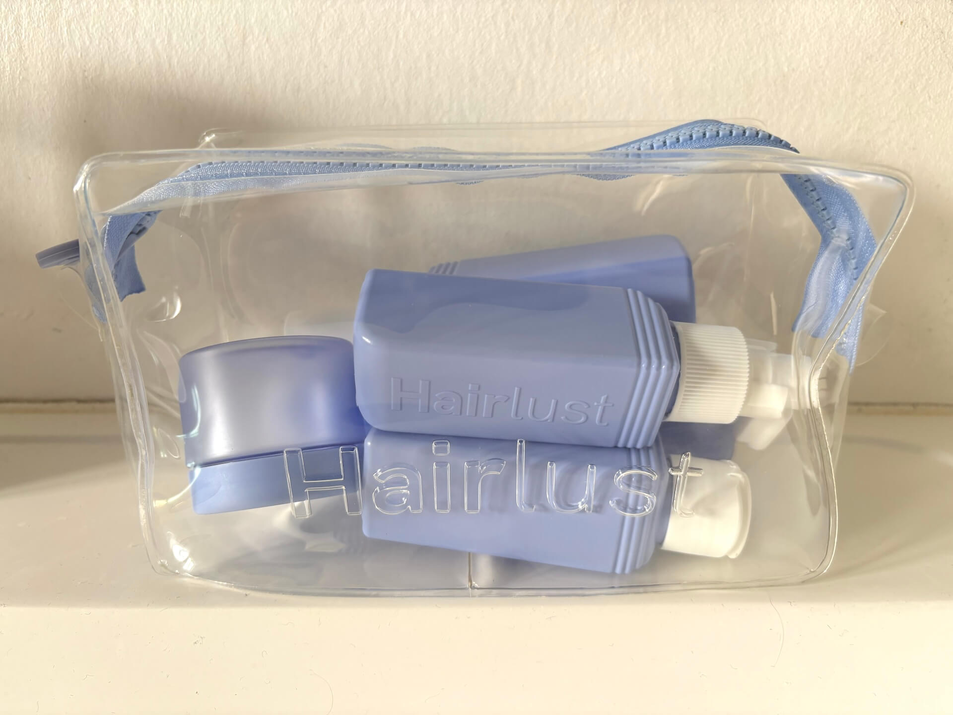 Hairlust Refillable Travel-Size Bottles toilettaske på toiletbord