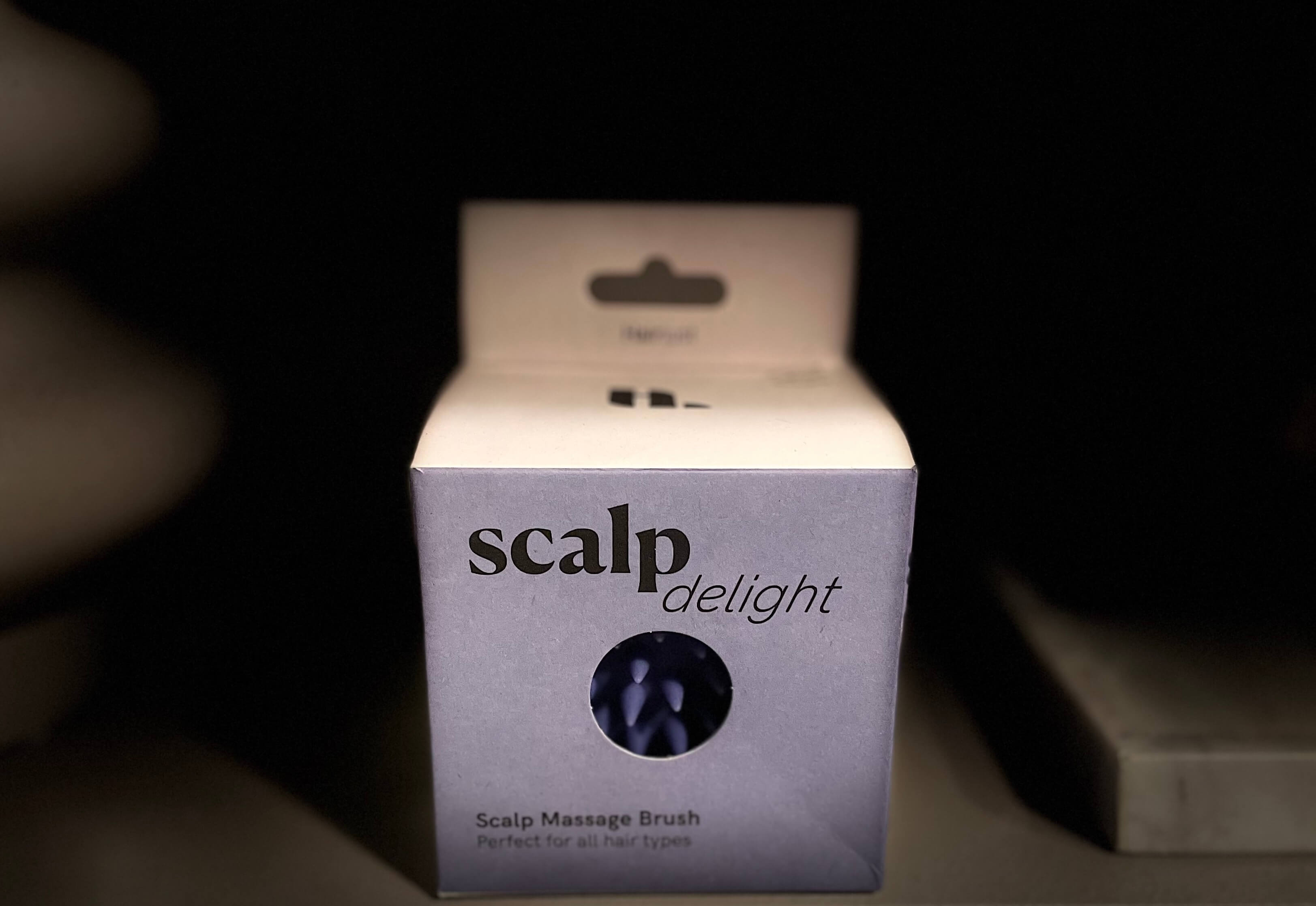 Hairlust Scalp Massage Brush i sin kasse på hylde