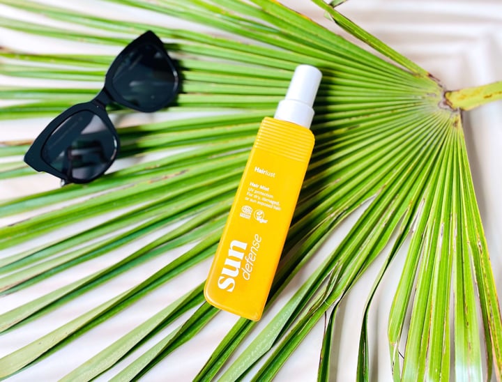 Hairlust Sun Defense Hair Mist solspray på palmeblad