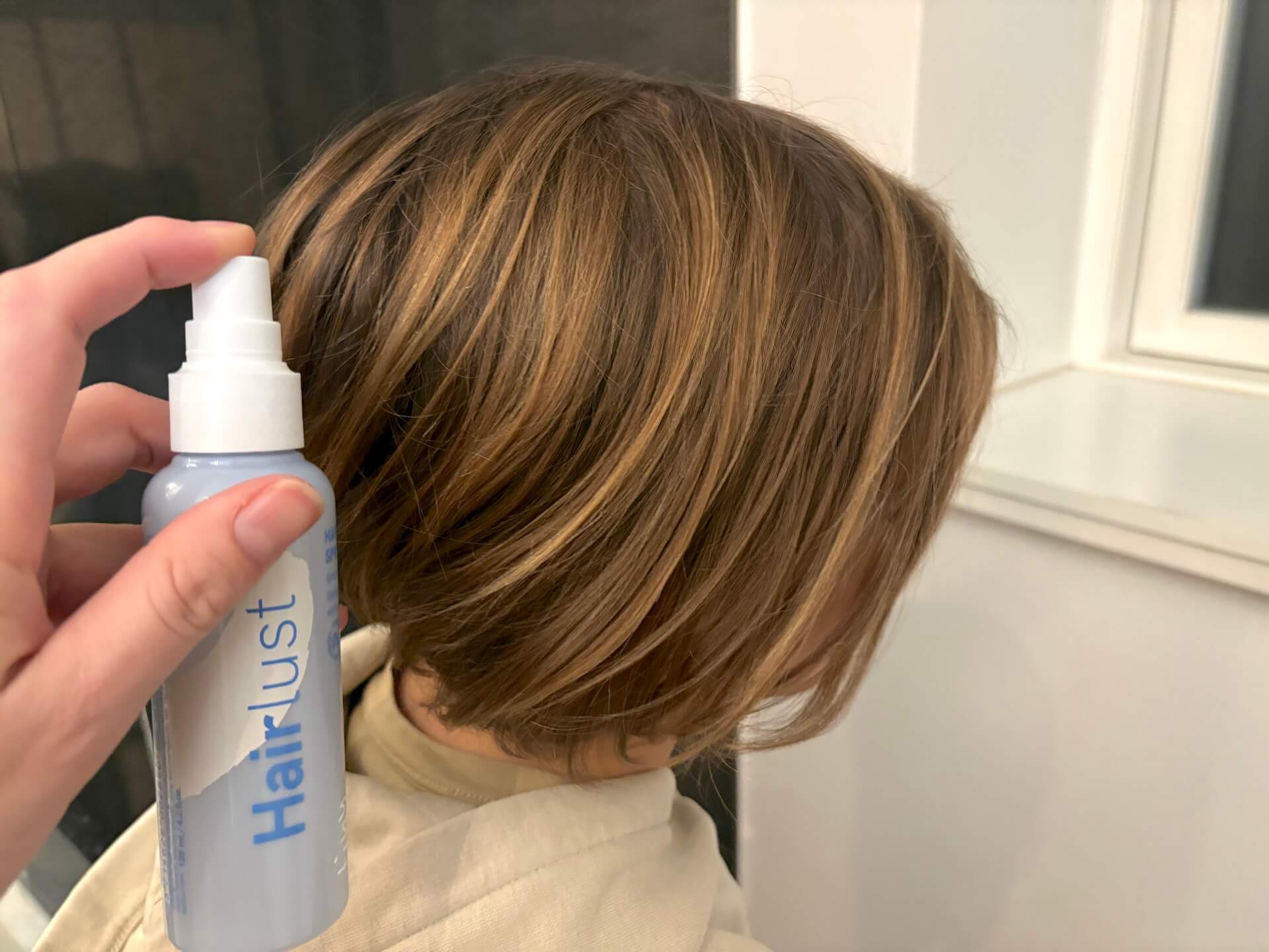 Hairlust Tiny Tangles Hair Detangler Spray ved siden af lang drengehår