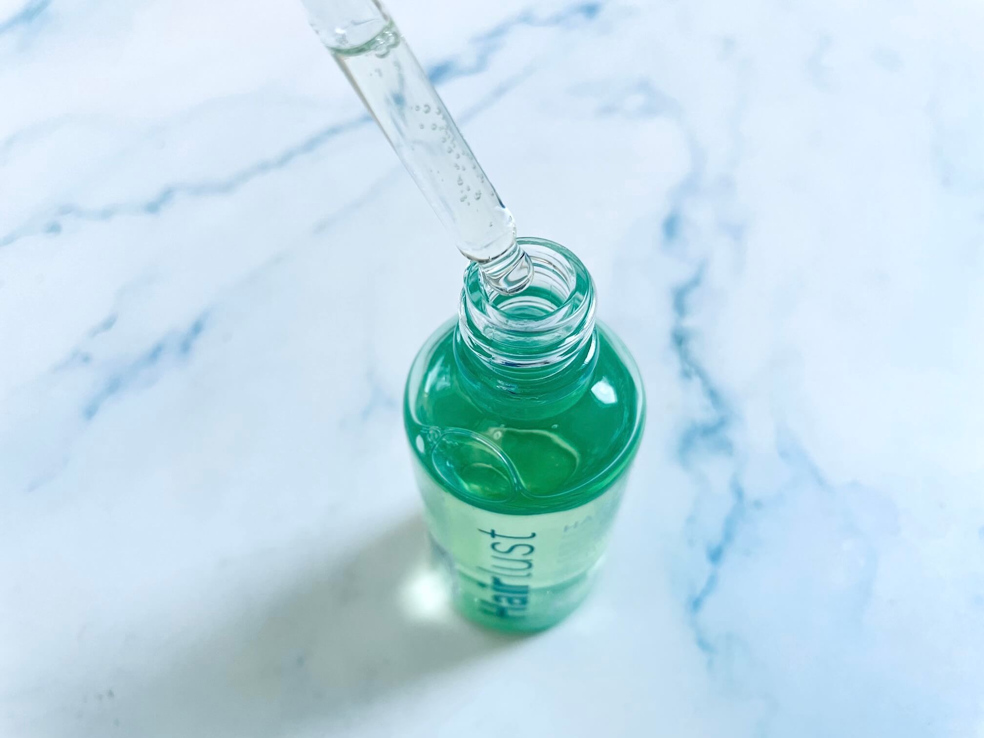 Hovedbundsolie grow perfect fra Hairlust dryppes ud af pipette