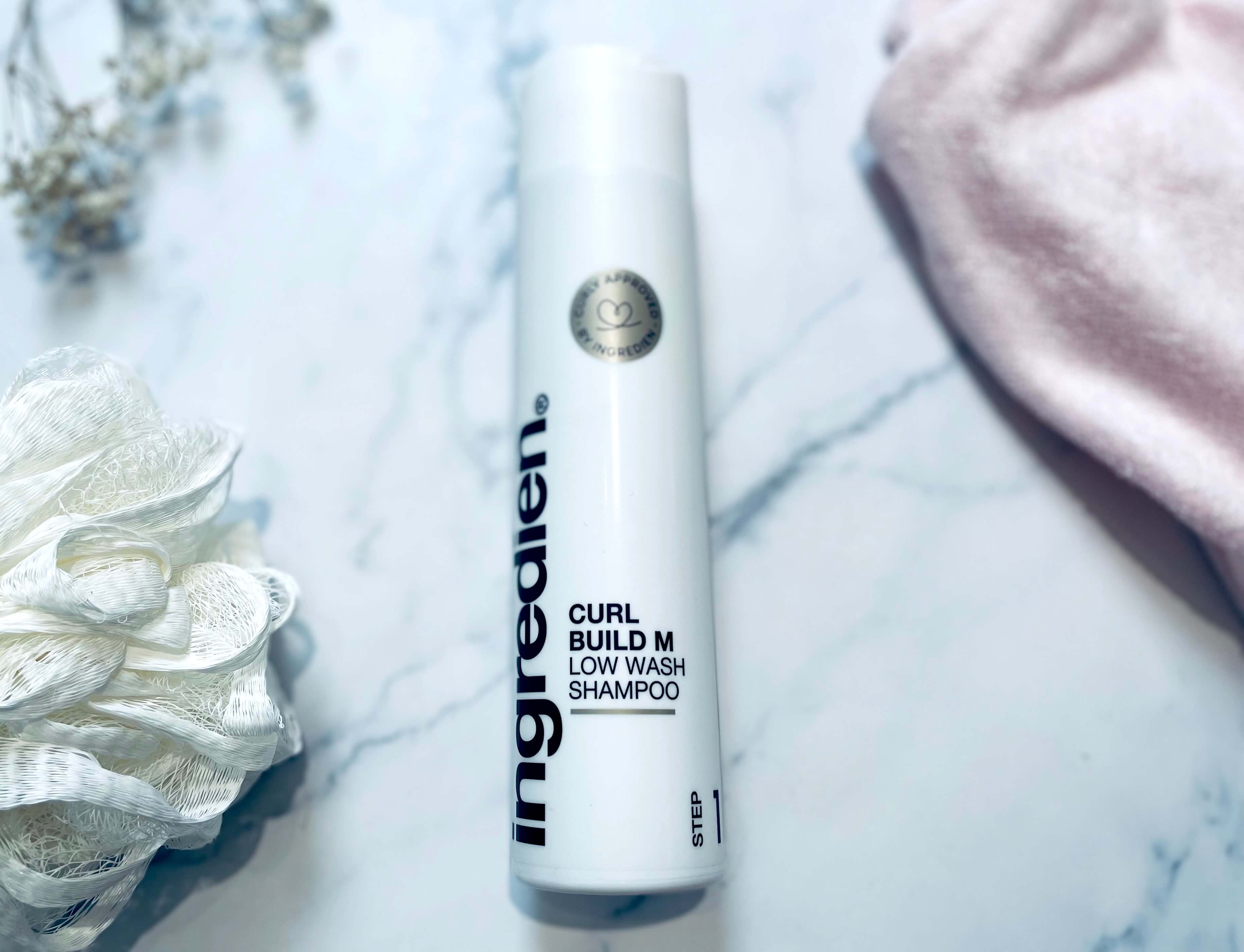ingredien Curl Build M Low Wash på bord med håndklæde
