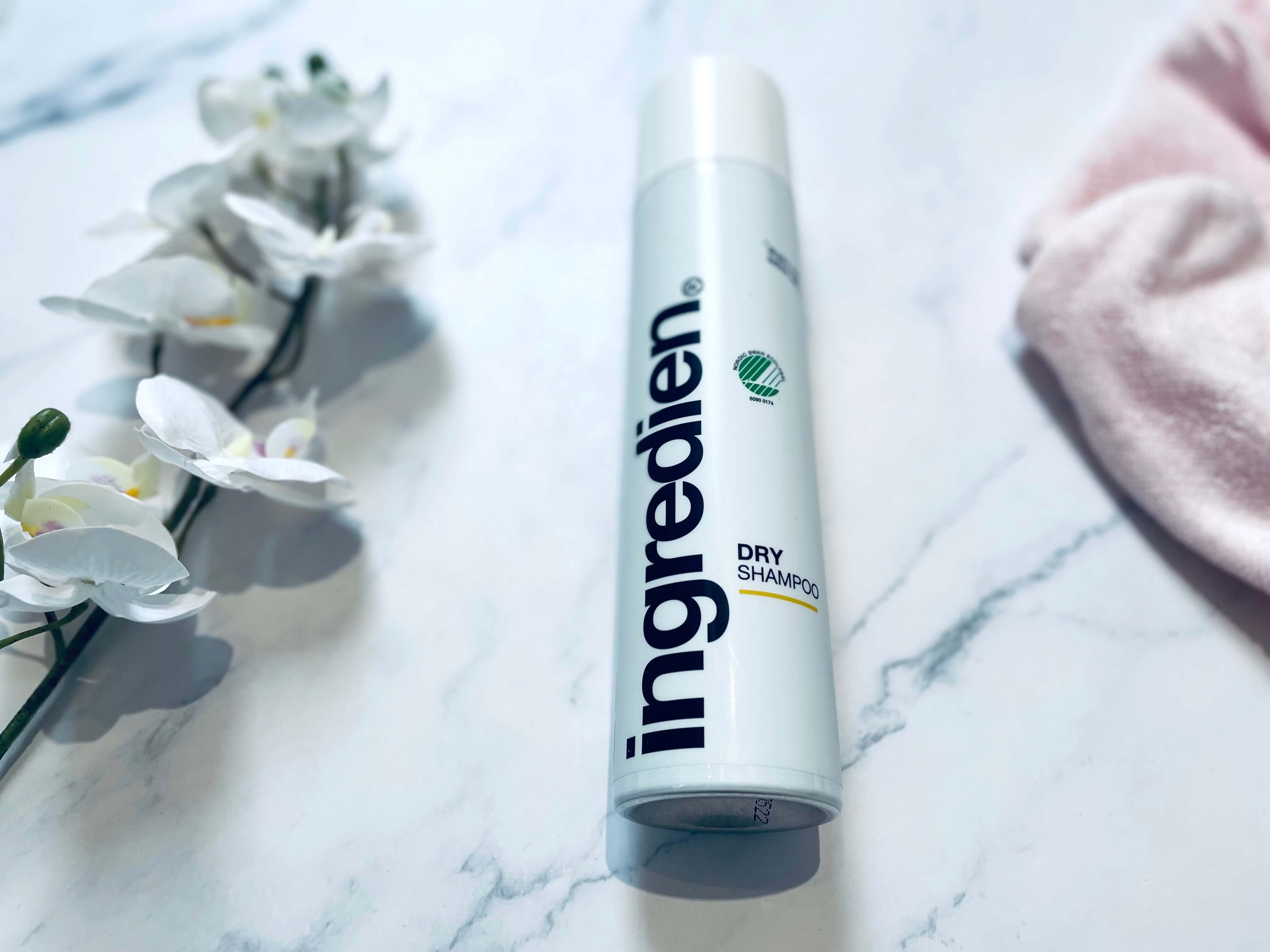 ingredien Dry Shampoo på bord med blomst og håndklæde