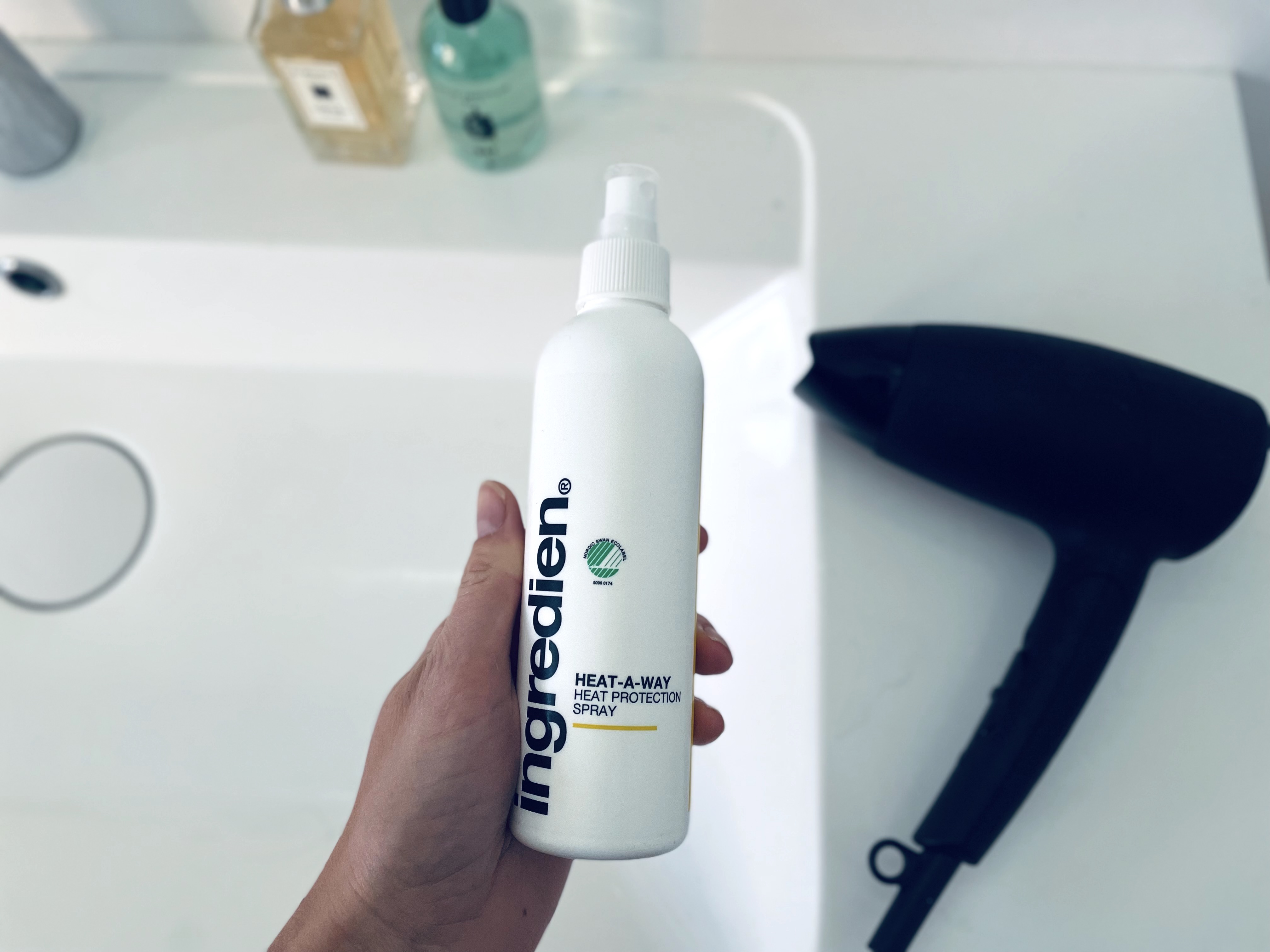 ingredien Heat-A-Way varmebeskyttende spray i hånd på badeværelse