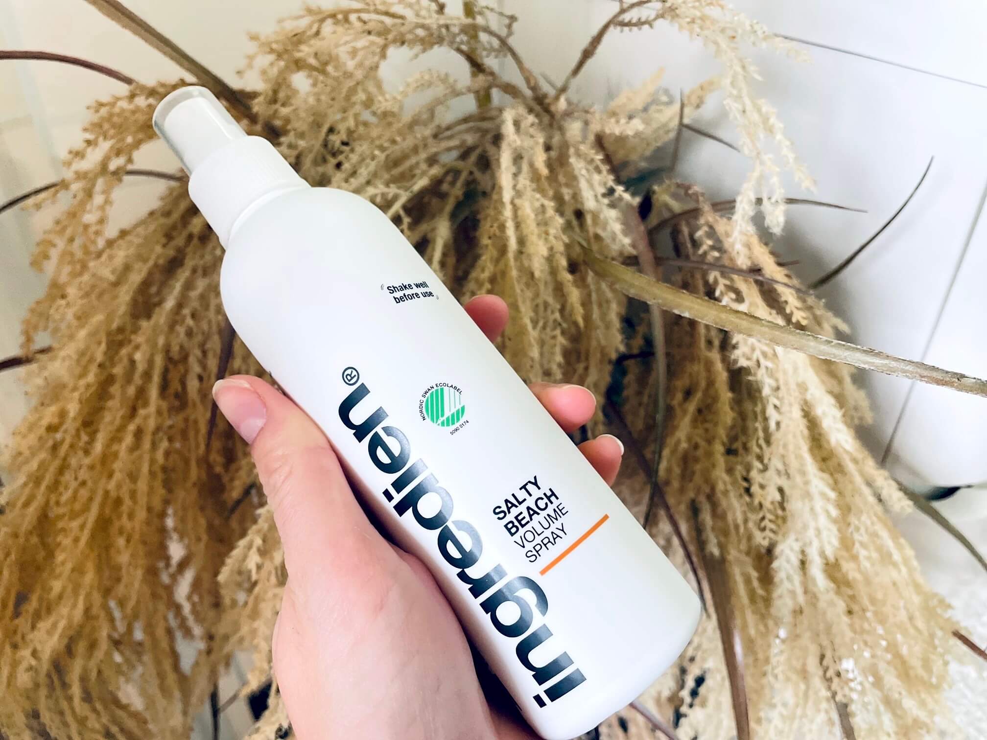 ingredien Salty Beach saltvandsspray i hånd foran plante