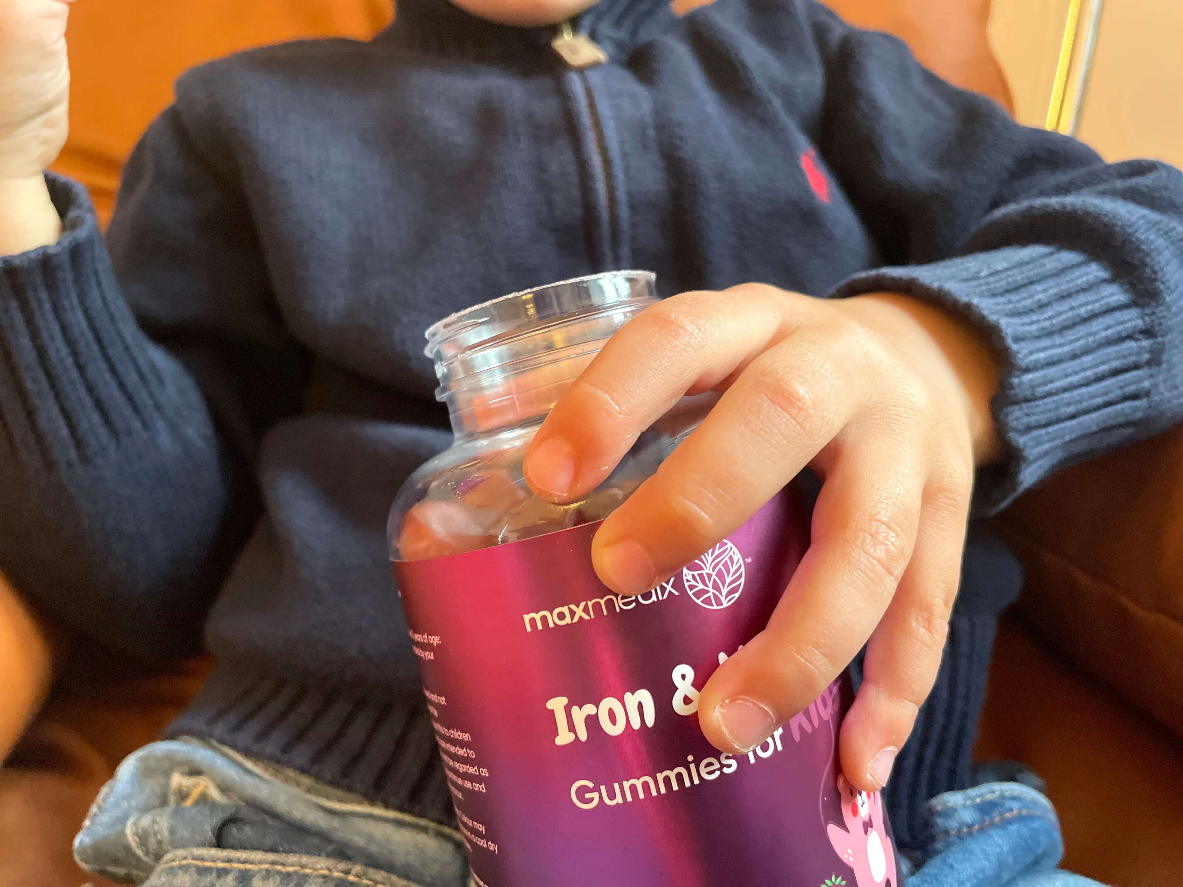 Jern og C-vitamin vingummier til børn i skødet på barn